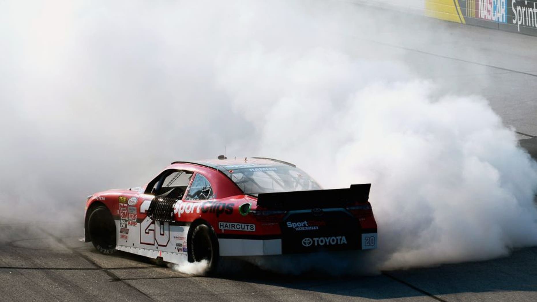 DARLINGTON, SC - SEPTEMBER 05: Denny Hamlin, driver of the #20 Sport Clips Toyota, celebrates with a burnout after winning the NASCAR XFINITY Series VFW Sport Clips Help A Hero 200 at Darlington Raceway on September 5, 2015 in Darlington, South Carolina. (Photo by Robert Laberge/NASCAR via Getty Images)