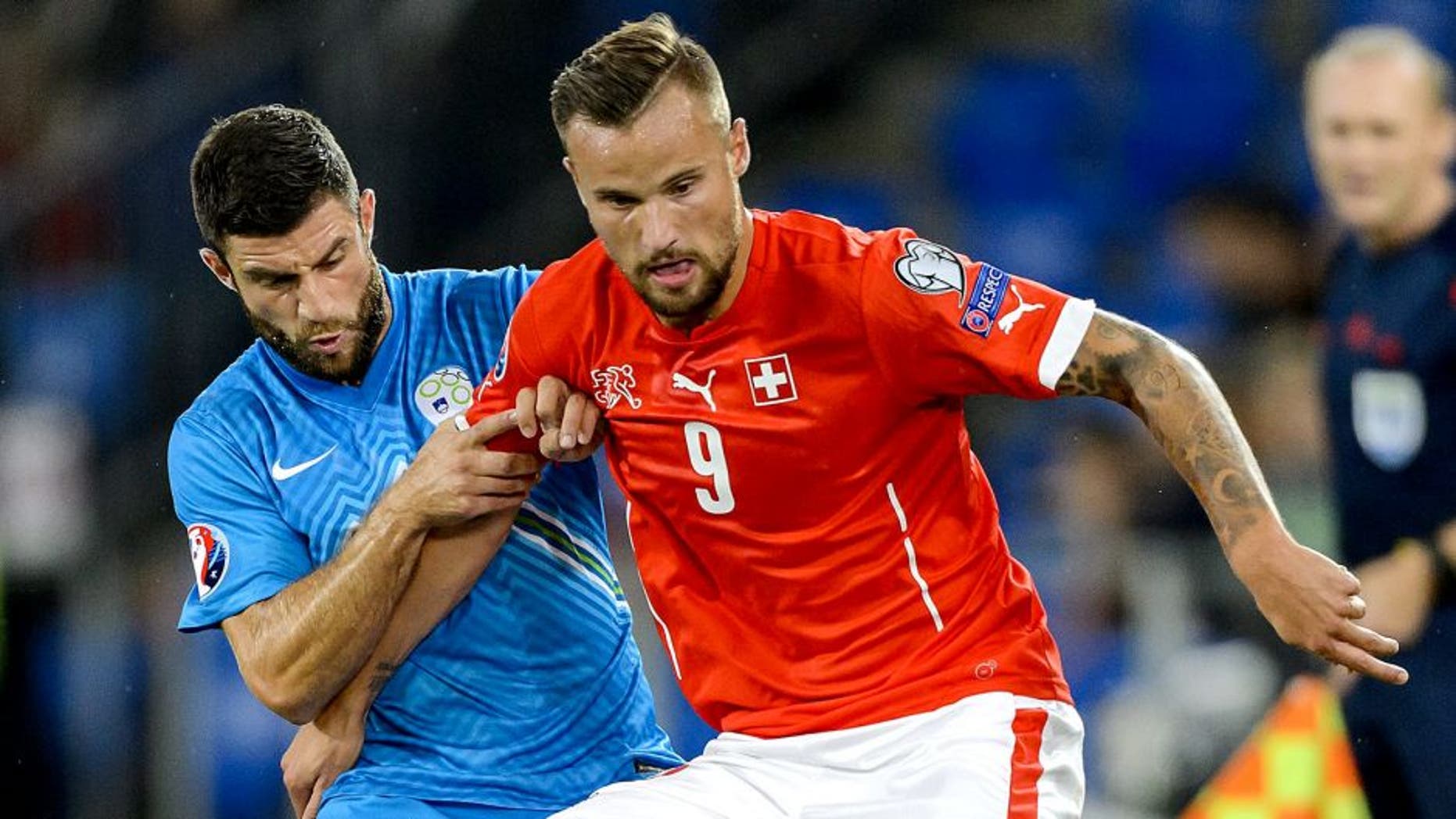 Slovenian defender Bojan Jokic (L) vies with Swiss forward Haris Seferovic during the Euro 2016 qualifying football match between Switzerland and Slovenia at the St. Jakob park stadium in Basel on September 5, 2015. AFP PHOTO / FABRICE COFFRINI (Photo credit should read FABRICE COFFRINI/AFP/Getty Images)