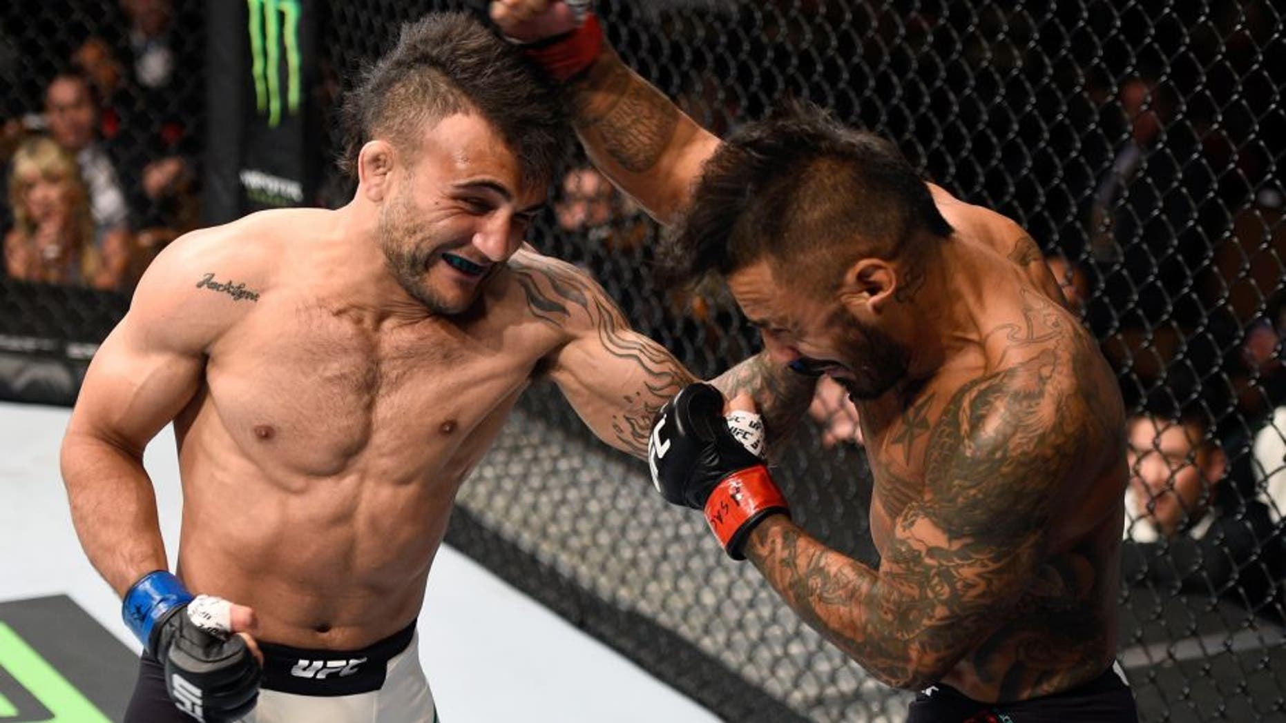 LAS VEGAS, NV - SEPTEMBER 05: (L-R) John Lineker punches Francisco Rivera in their bantamweight bout during the UFC 191 event inside MGM Grand Garden Arena on September 5, 2015 in Las Vegas, Nevada. (Photo by Jeff Bottari/Zuffa LLC/Zuffa LLC via Getty Images)