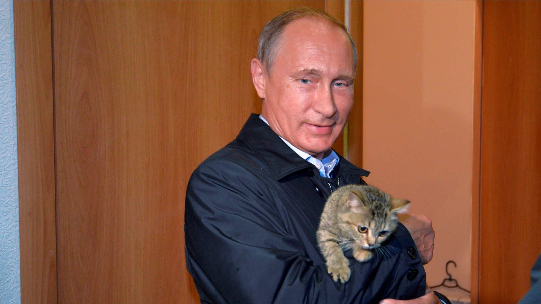 Sept. 4, 2015: Russian President Vladimir Putin holds a cat as he inspects housing built for victims of wildfires in the village of Krasnopolye, in Khakassia, a region in southeastern Siberia, Russia.