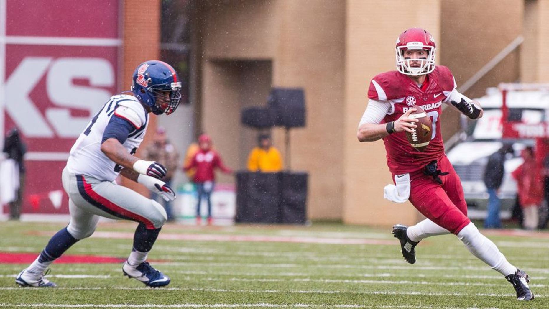 Nov 22, 2014; Fayetteville, AR, USA; Arkansas Razorbacks quarterback Brandon Allen (10) looks to pass while pursued by Ole Miss Rebels defensive tackle Issac Gross (94) during a game at Donald W. Reynolds Razorback Stadium. Arkansas defeated Ole Miss 30-0. Mandatory Credit: Beth Hall-USA TODAY Sports