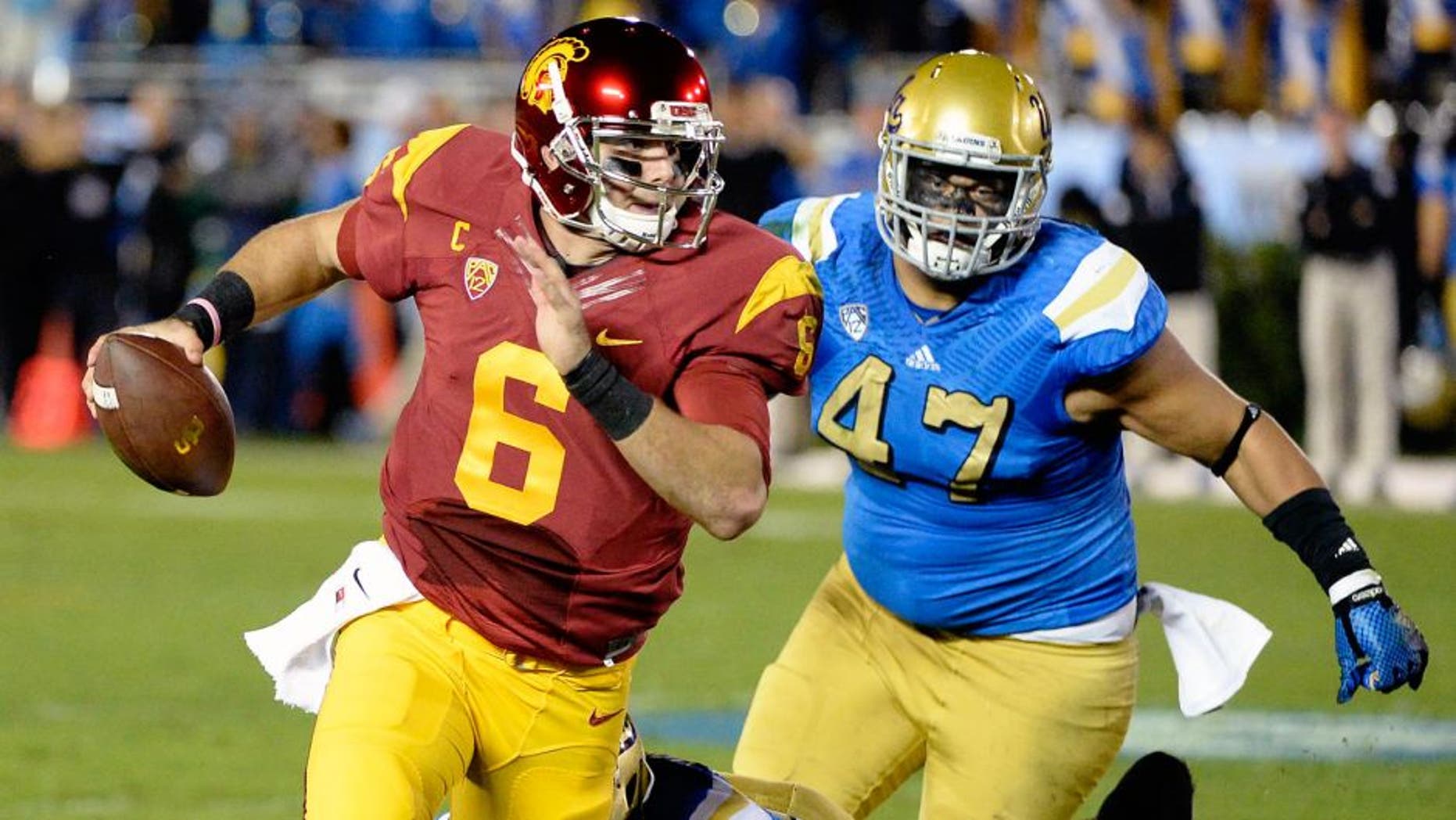 Nov 22, 2014; Pasadena, CA, USA; Southern California Trojans quarterback Cody Kessler (6) is pressured by UCLA Bruins defensive lineman Eddie Vanderdoes (47) and linebacker Deon Hollins (58) during the first half at the Rose Bowl. Mandatory Credit: Richard Mackson-USA TODAY Sports