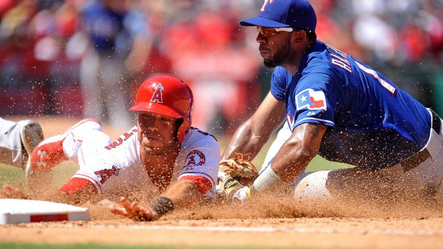 September 6, 2015; Anaheim, CA, USA; Los Angeles Angels third baseman Taylor Featherston (8) is tagged out at first after trying to steal second against Texas Rangers shortstop Elvis Andrus (1) in the fourth inning at Angel Stadium of Anaheim. Mandatory Credit: Gary A. Vasquez-USA TODAY Sports
