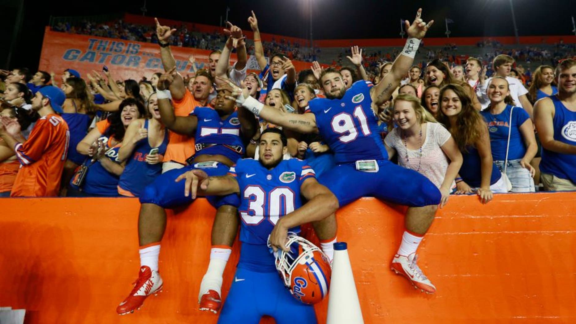 Sep 5, 2015; Gainesville, FL, USA; Florida Gators defensive lineman Joey Ivie (91), Florida Gators offensive lineman Andrew Mike (77) and teammates celebrate as they beat the New Mexico State Aggies at Ben Hill Griffin Stadium. Florida Gators defeated the New Mexico State Aggies 61-13. Mandatory Credit: Kim Klement-USA TODAY Sports
