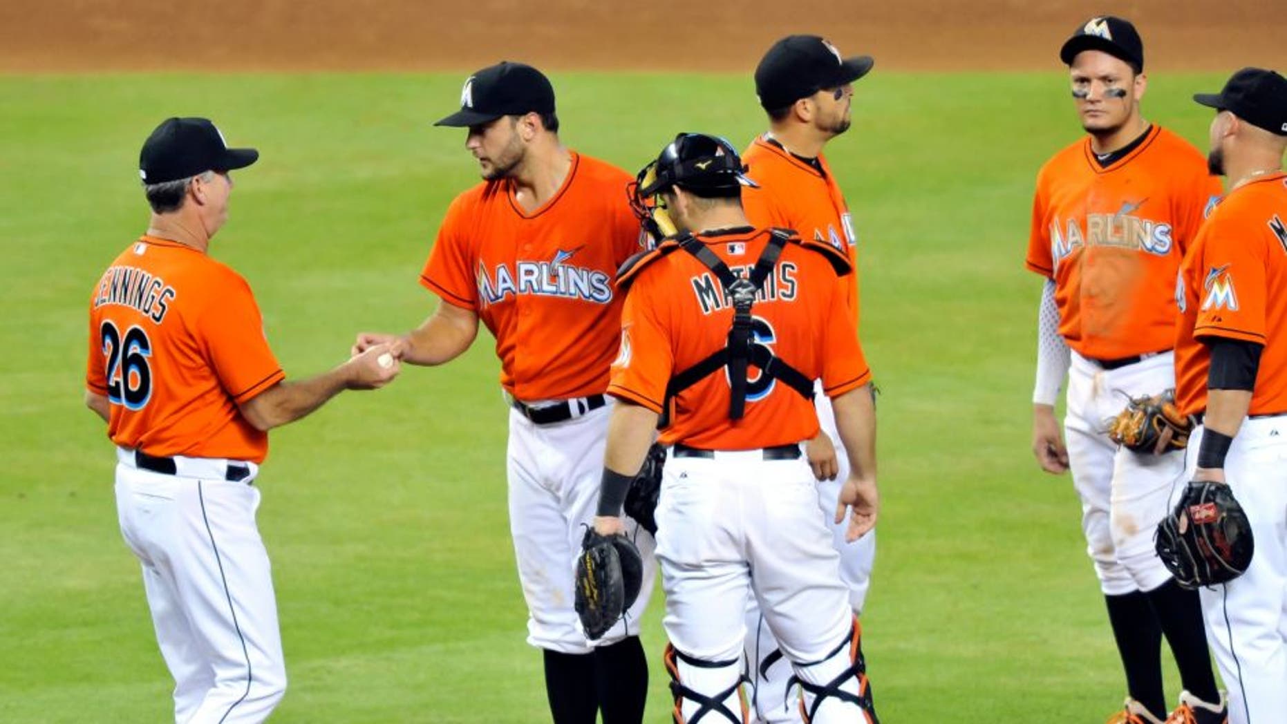 Sep 6, 2015; Miami, FL, USA; Miami Marlins manager Dan Jennings (left) takes starting pitcher Jarred Cosart (center) out of the game during the fifth inning against the New York Mets at Marlins Park. Mandatory Credit: Steve Mitchell-USA TODAY Sports