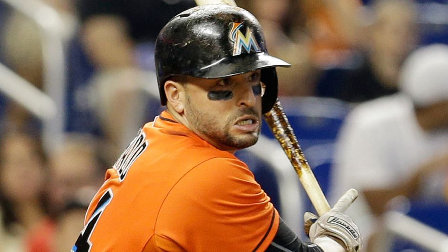 Miami Marlins' Martin Prado (14) follows through on a single against the New York Mets in the fourth inning of a baseball game, Sunday, Sept. 6, 2015, in Miami. (AP Photo/Alan Diaz)
