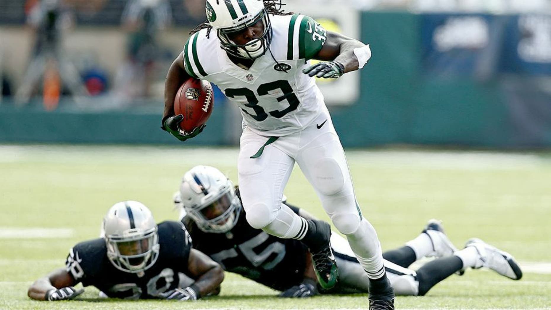 EAST RUTHERFORD, NJ - SEPTEMBER 07: Chris Ivory #33 of the New York Jets rushes after evading tackle attempts by T.J. Carrie #38 and Sio Moore #55 of the Oakland Raiders during the third quarter of a game at MetLife Stadium on September 7, 2014 in East Rutherford, New Jersey. (Photo by Jeff Zelevansky/Getty Images)
