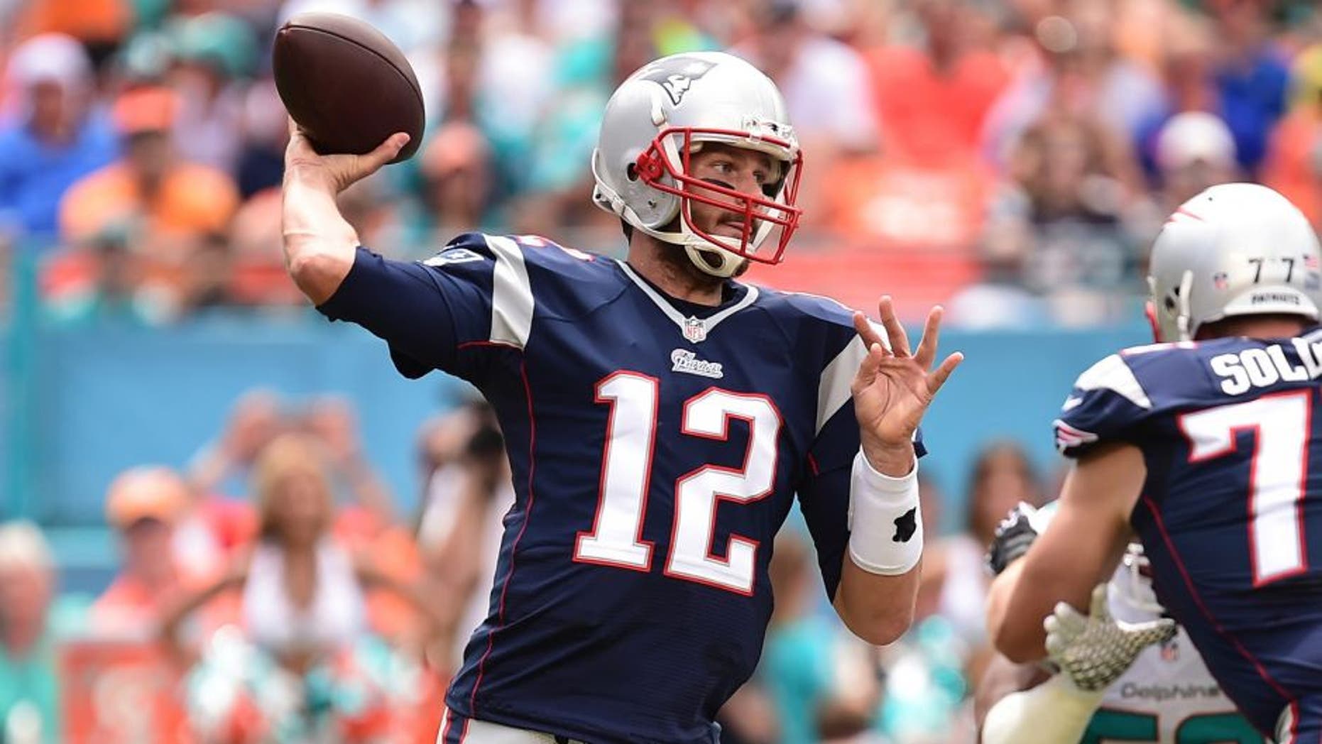 Sep 7, 2014; Miami Gardens, FL, USA; New England Patriots quarterback Tom Brady (12) drops back to pass in the first quarter against the Miami Dolphins at Sun Life Stadium. Mandatory Credit: Brad Barr-USA TODAY Sports