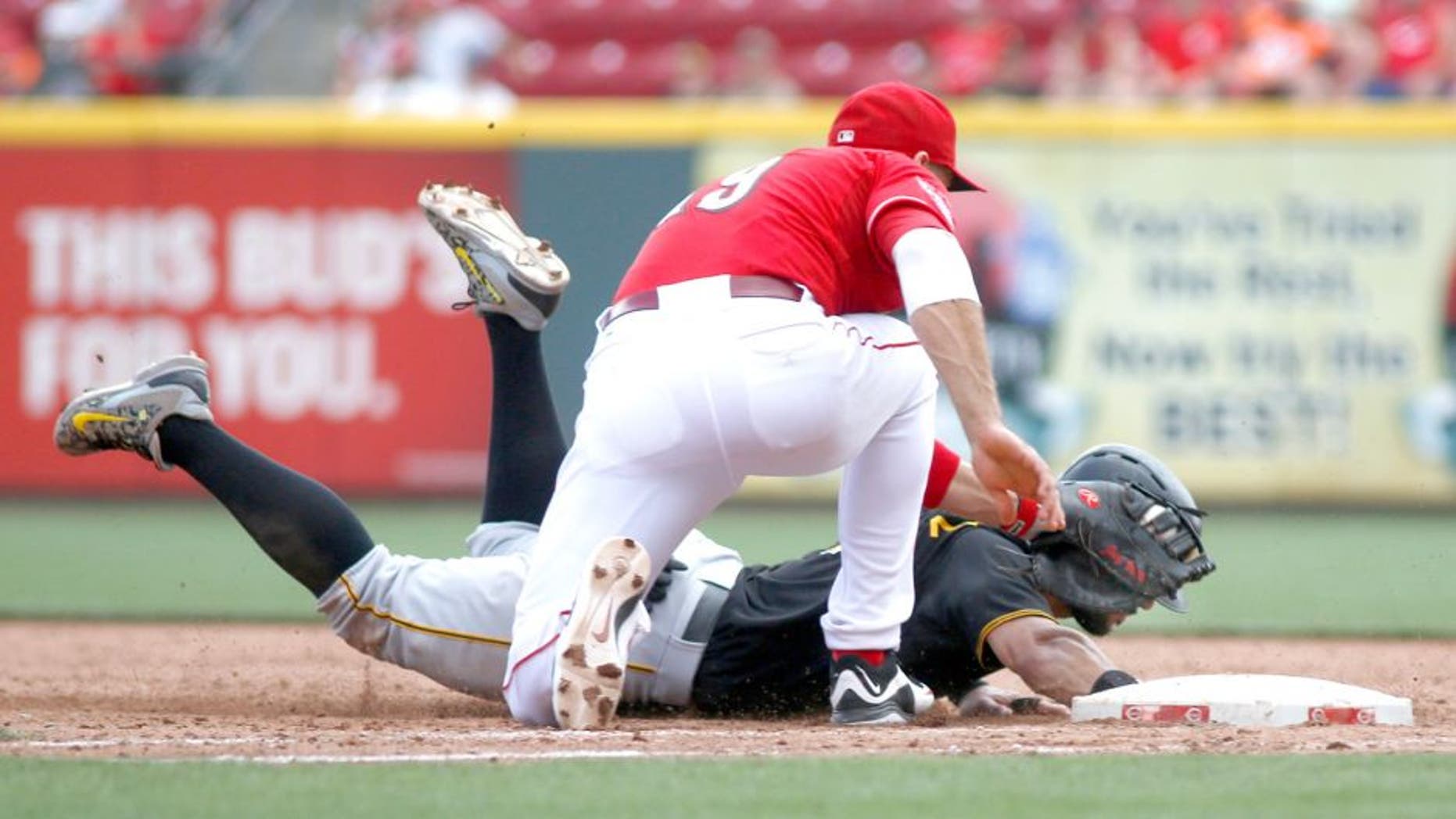 Sep 7, 2015; Cincinnati, OH, USA; Pittsburgh Pirates first baseman Sean Rodriguez (3) is picked off at first by Cincinnati Reds first baseman Joey Votto (19) in the ninth inning at Great American Ball Park. The Reds won 3-1. Mandatory Credit: David Kohl-USA TODAY Sports
