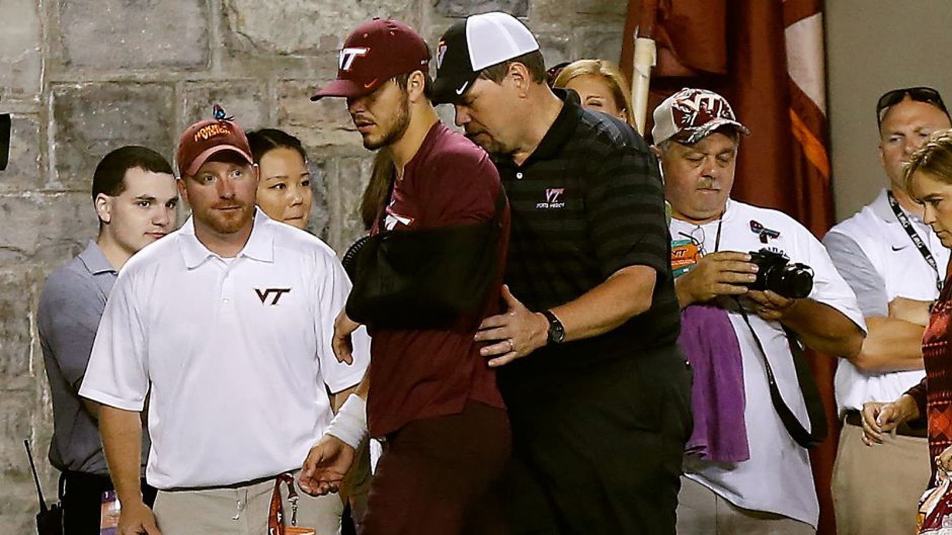 Sep 7, 2015; Blacksburg, VA, USA; Virginia Tech Hokies quarterback Michael Brewer (middle) leaves the field with his left arm in a sling after being injured against the Ohio State Buckeyes in the third quarter at Lane Stadium. Mandatory Credit: Geoff Burke-USA TODAY Sports