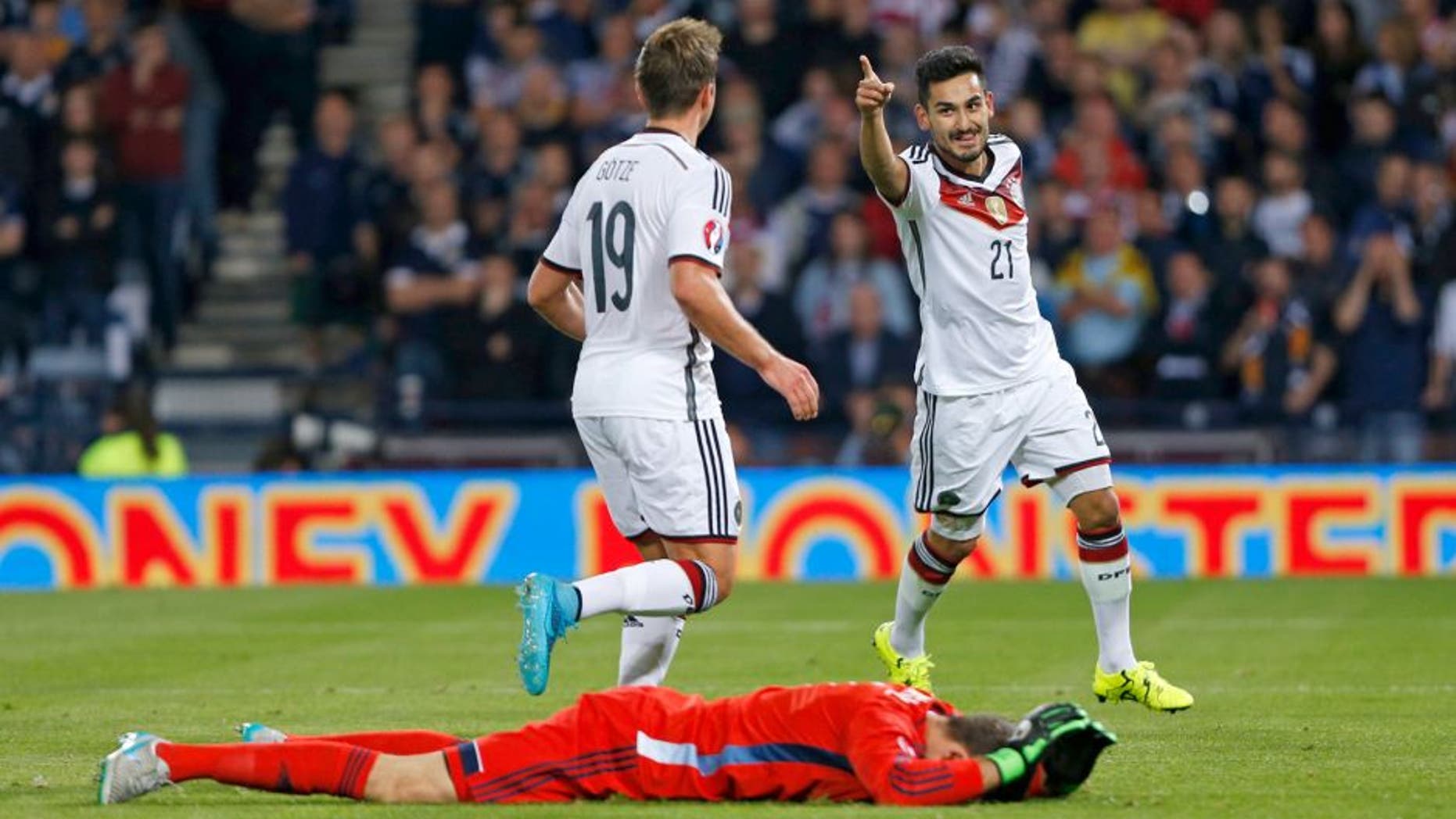Football - Scotland v Germany - UEFA Euro 2016 Qualifying Group D - Hampden Park, Glasgow, Scotland - 7/9/15 Ilkay Gundogan celebrates with team mates after scoring the third goal for Germany as Scotland's David Marshall looks dejected Reuters / Russell Cheyne Livepic EDITORIAL USE ONLY.