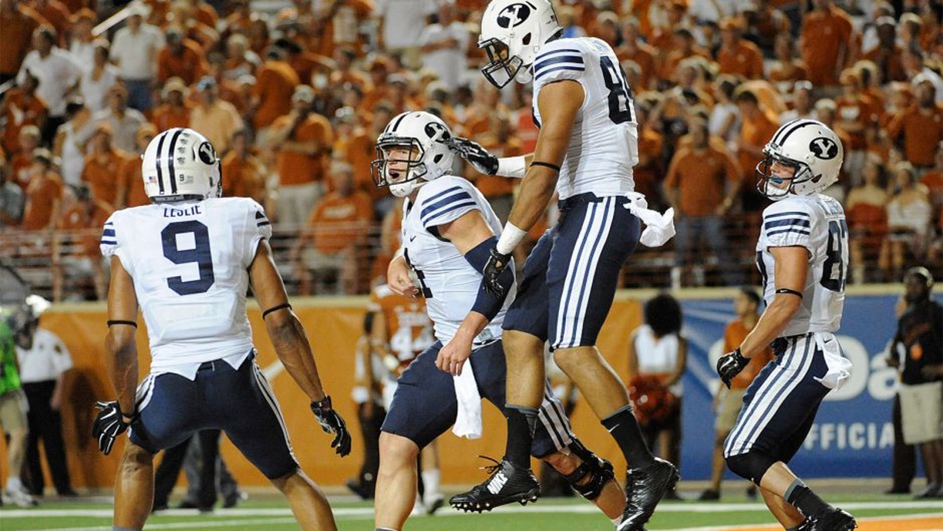 Sep 6, 2014; Austin, TX, USA; Brigham Young Cougars quarterback Taysom Hill (4) and tight end Devin Mahina (84) and wide receivers Jordan Leslie (9) and Mitchell Juergens (87) react after a touchdown against the Texas Longhorns during the second half at Darrell K Royal-Texas Memorial Stadium. BYU beat Texas 41-7. Mandatory Credit: Brendan Maloney-USA TODAY Sports