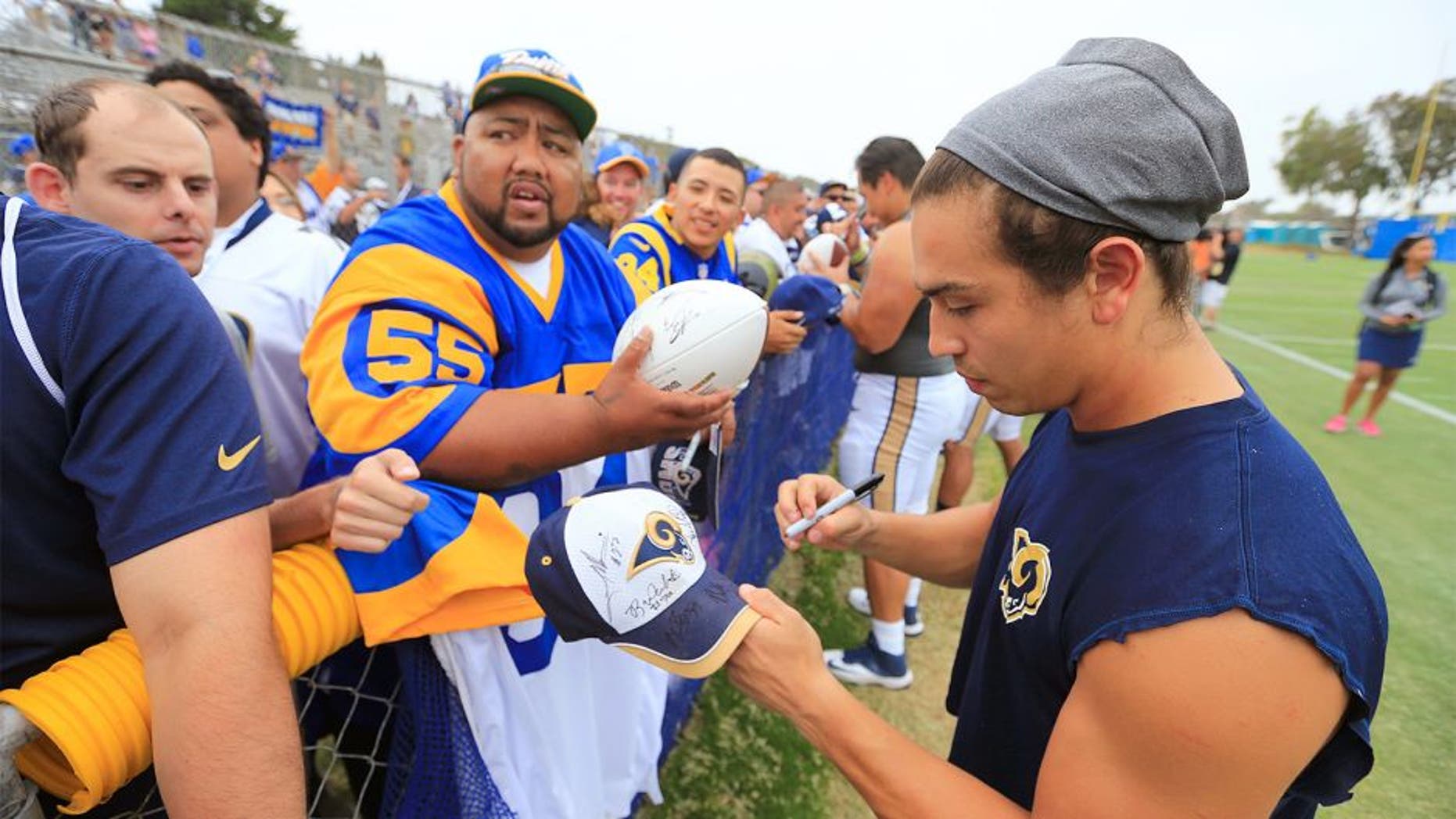 OXNARD, CALIF. -- MONDAY, AUGUST 17, 2015: St. Louis Rams wide receiver and U.S. Army veteran Daniel Rodriguez signs autographs for hopeful Los Angeles Rams fans following the St. Louis Rams-Dallas Cowboys NFL scrimmage at training camp in Oxnard Monday, Aug. 17, 2015. The Dallas Cowboys scrimmaged against the St. Louis Rams. The Rams are making an appearance in Southern California now that they're trying to possibly move back. Photo taken in Oxnard, Calif., on Aug. 17, 2015. (Allen J. Schaben / Los Angeles Times)