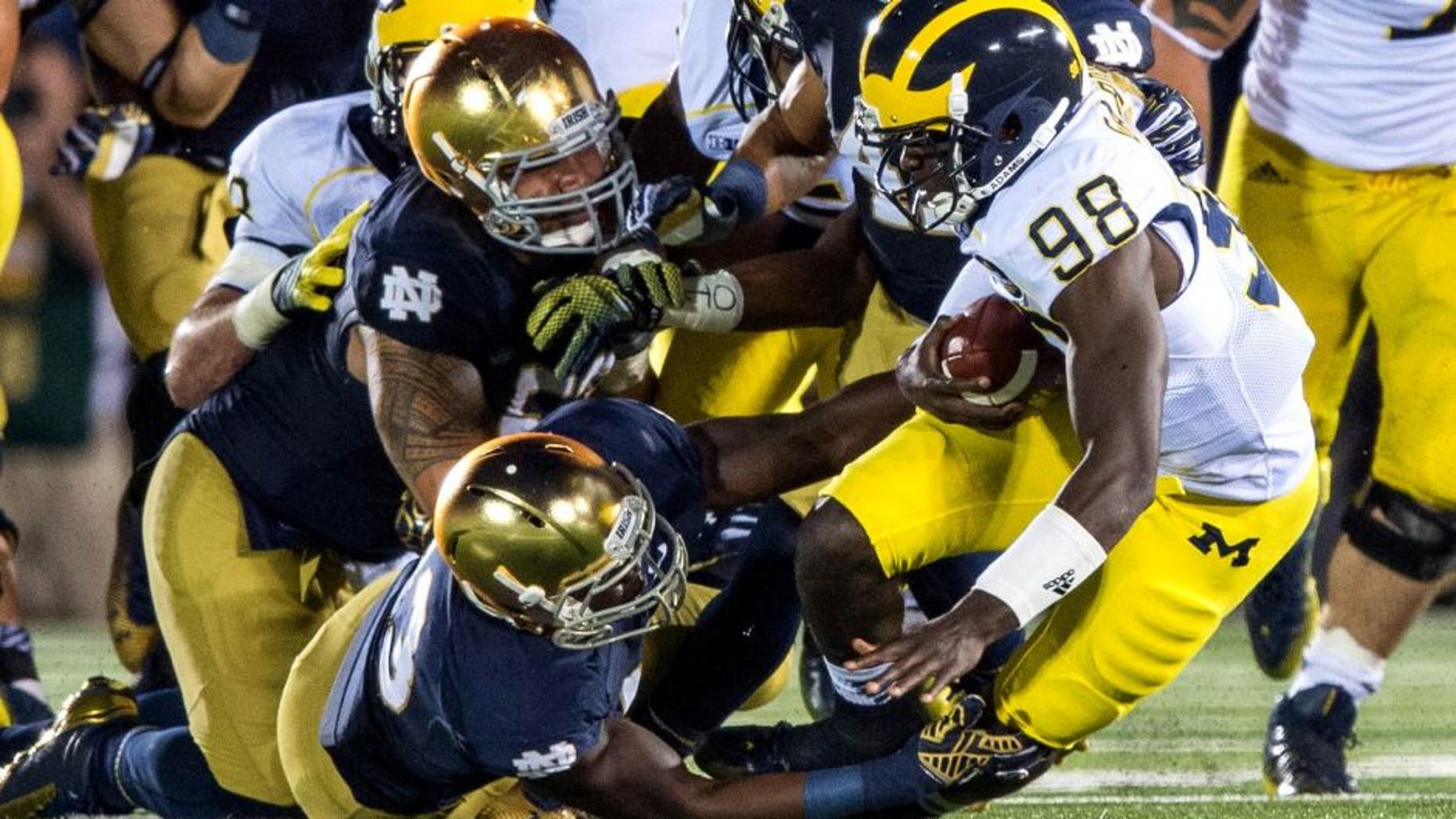 Sep 6, 2014; South Bend, IN, USA; Michigan Wolverines quarterback Devin Gardner (98) is sacked by Notre Dame Fighting Irish linebacker Kolin Hill (43) defensive lineman Justin Utupo (53) and cornerback Matthias Farley (41) in the fourth quarter at Notre Dame Stadium. Notre Dame won 31-0. Mandatory Credit: Matt Cashore-USA TODAY Sports