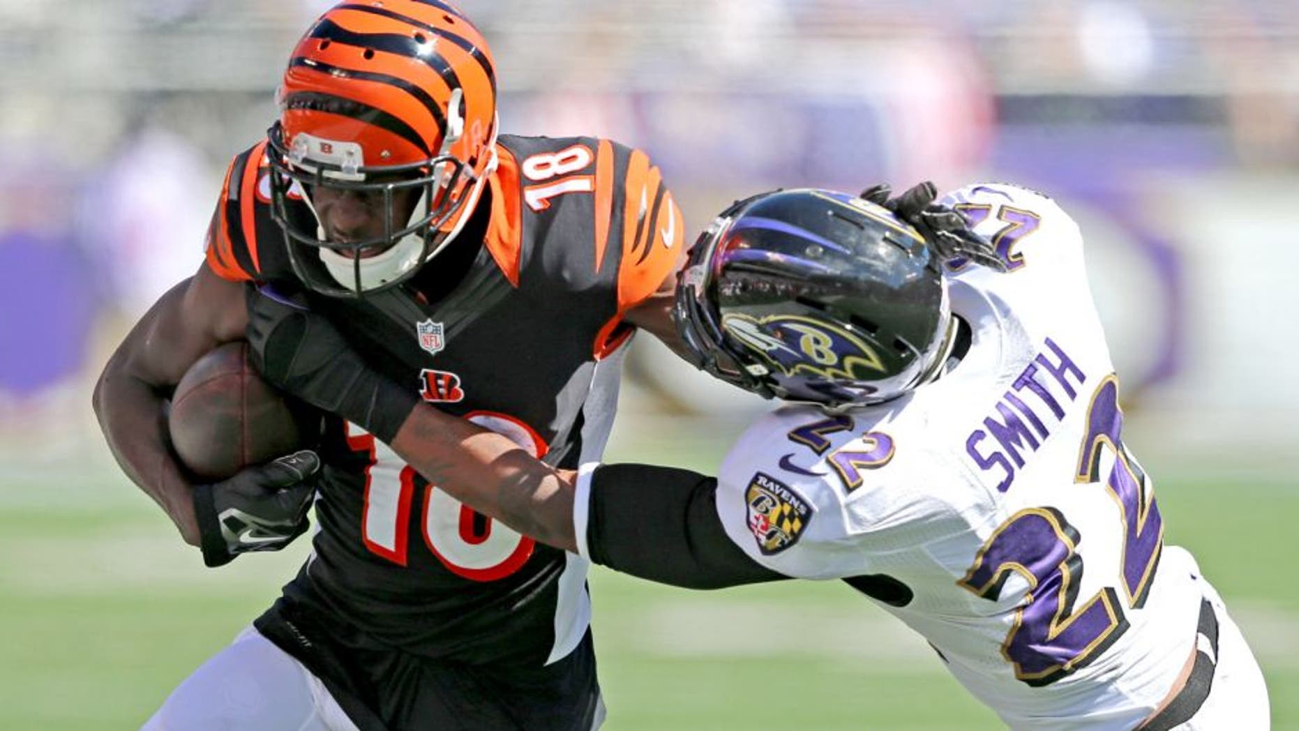 Sep 7, 2014; Baltimore, MD, USA; Cincinnati Bengals wide receiver A.J. Green (18) is tackled after a catch by Baltimore Ravens cornerback Jimmy Smith (22) at M&T Bank Stadium. Mandatory Credit: Mitch Stringer-USA TODAY Sports