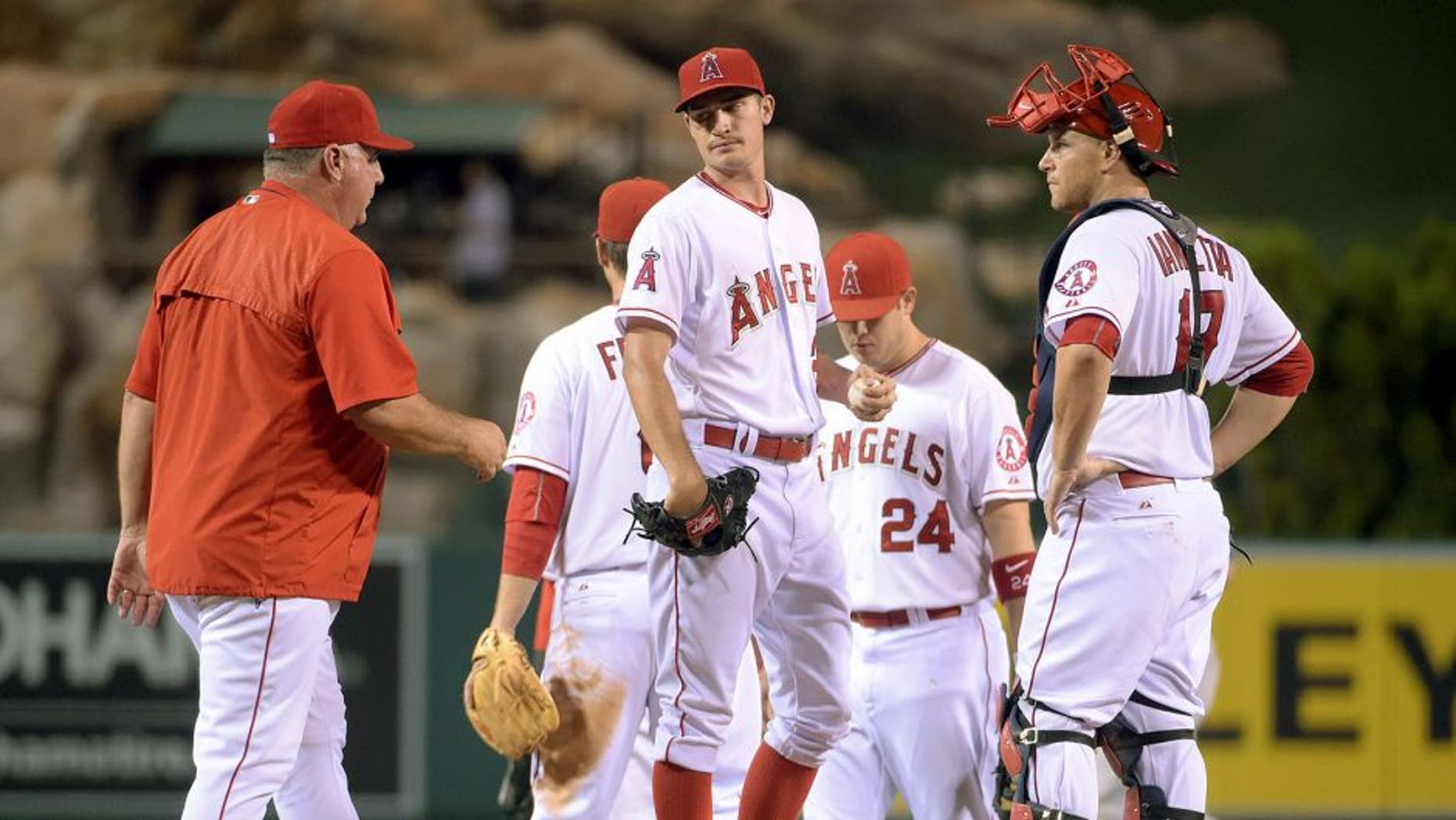 Sep 8, 2015; Anaheim, CA, UCA; Los Angeles Angels pitcher Andrew Hearney (center) reacts after being removed by manager Mike Scioscia (left) as catcher Chris Iannetta watches against the Los Angeles Dodgers at Angel Stadium of Anaheim. Mandatory Credit: Kirby Lee-USA TODAY Sports