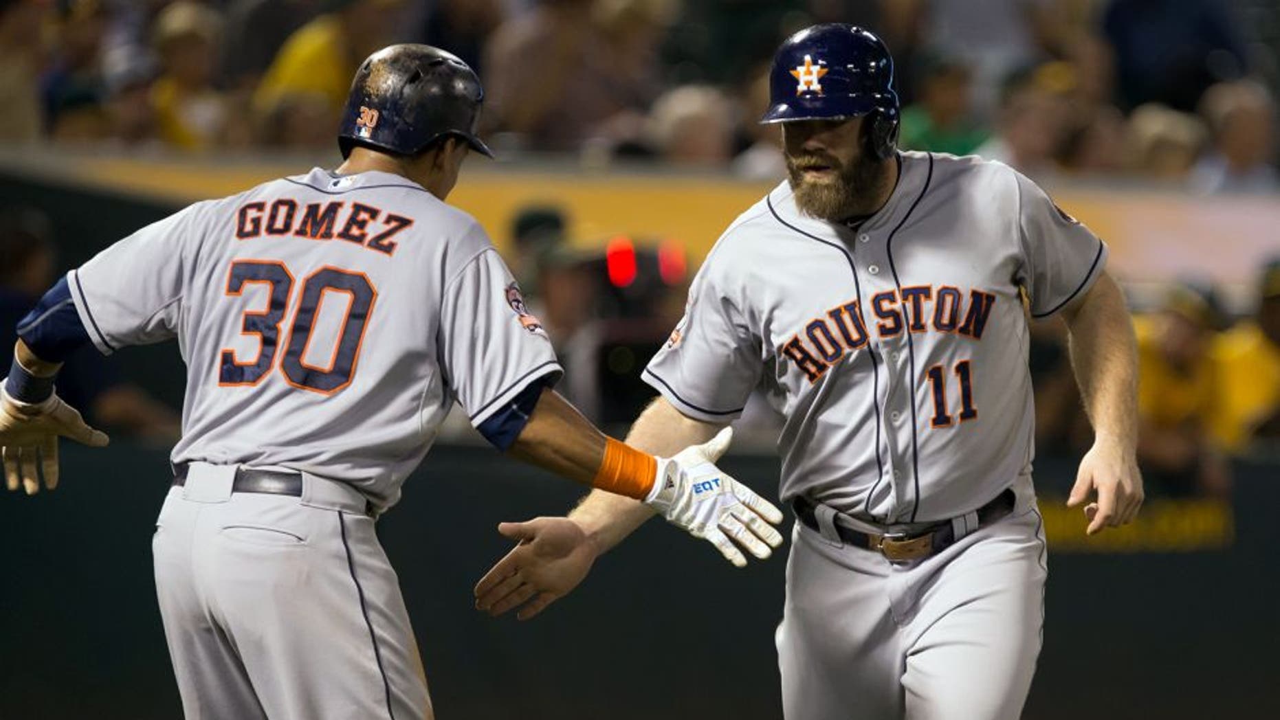 Sep 9, 2015; Oakland, CA, USA; Houston Astros designated hitter Evan Gattis (11) high fives center fielder Carlos Gomez (30) after batting him in on a two run home run against the Oakland Athletics during the fifth inning at O.co Coliseum. Mandatory Credit: Kelley L Cox-USA TODAY Sports