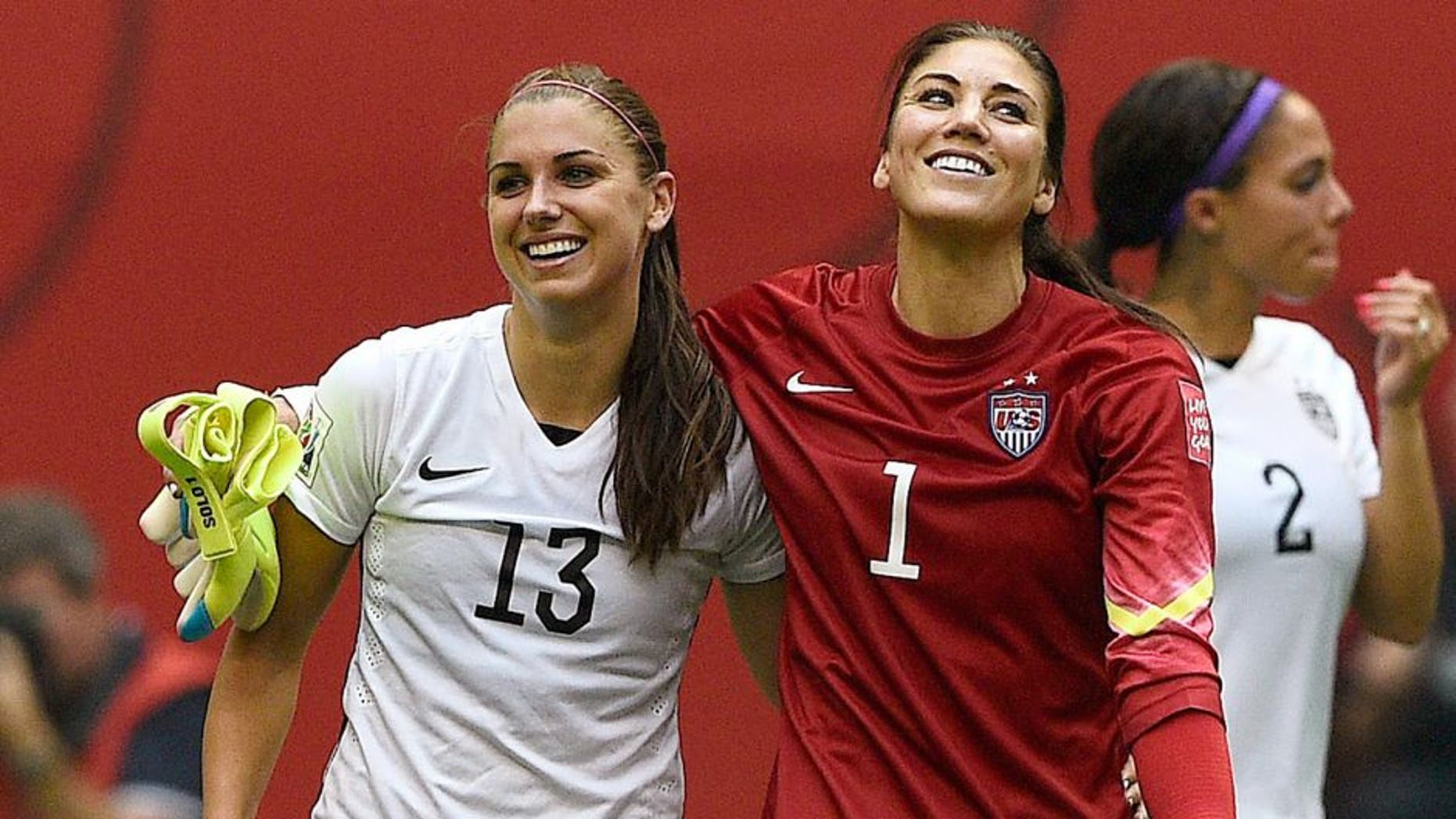 USA forward Alex Morgan (L) and goalkeeper Hope Solo celebrate after winning final football match between USA and Japan during their 2015 FIFA Women's World Cup at the BC Place Stadium in Vancouver on July 5, 2015. AFP PHOTO / FRANCK FIFE (Photo credit should read FRANCK FIFE/AFP/Getty Images)