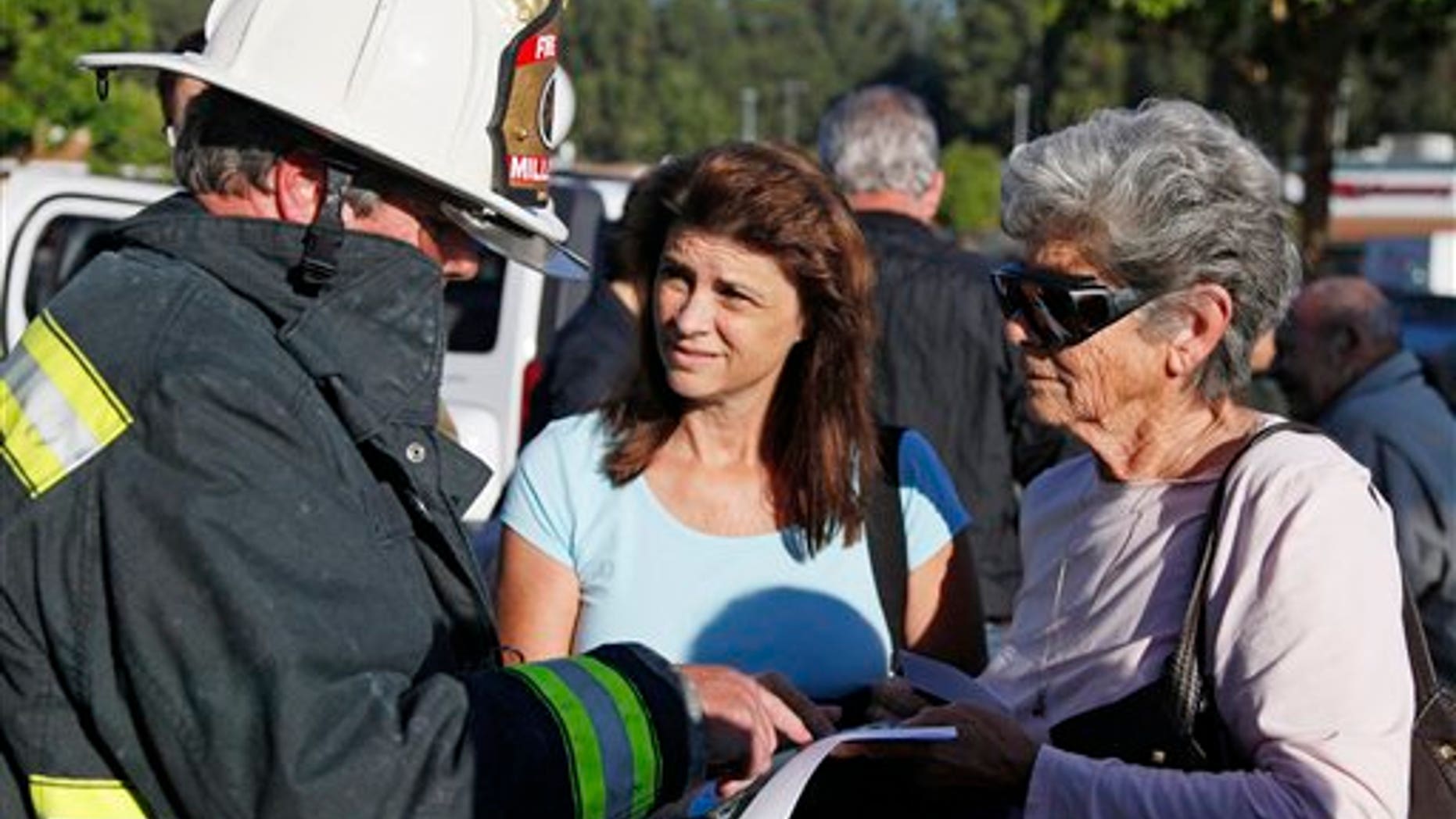 Millbrae, Calif., fire chief Dennis Haage, left, talks with San Bruno, Calif., residents Toni Vaccari, right, and her daughter, Debbie Shea, about returning to their homes near last night's gas explosion following a news conference, Friday, Sept. 10, 2010, at a shopping center in San Bruno. Fire crews sprayed water on smoldering homes Friday morning after a massive explosion apparently triggered by a broken gas line sent flames roaring through a neighborhood near San Francisco, killing at least six people and injuring dozens, officials said. (AP Photo/Eric Risberg)