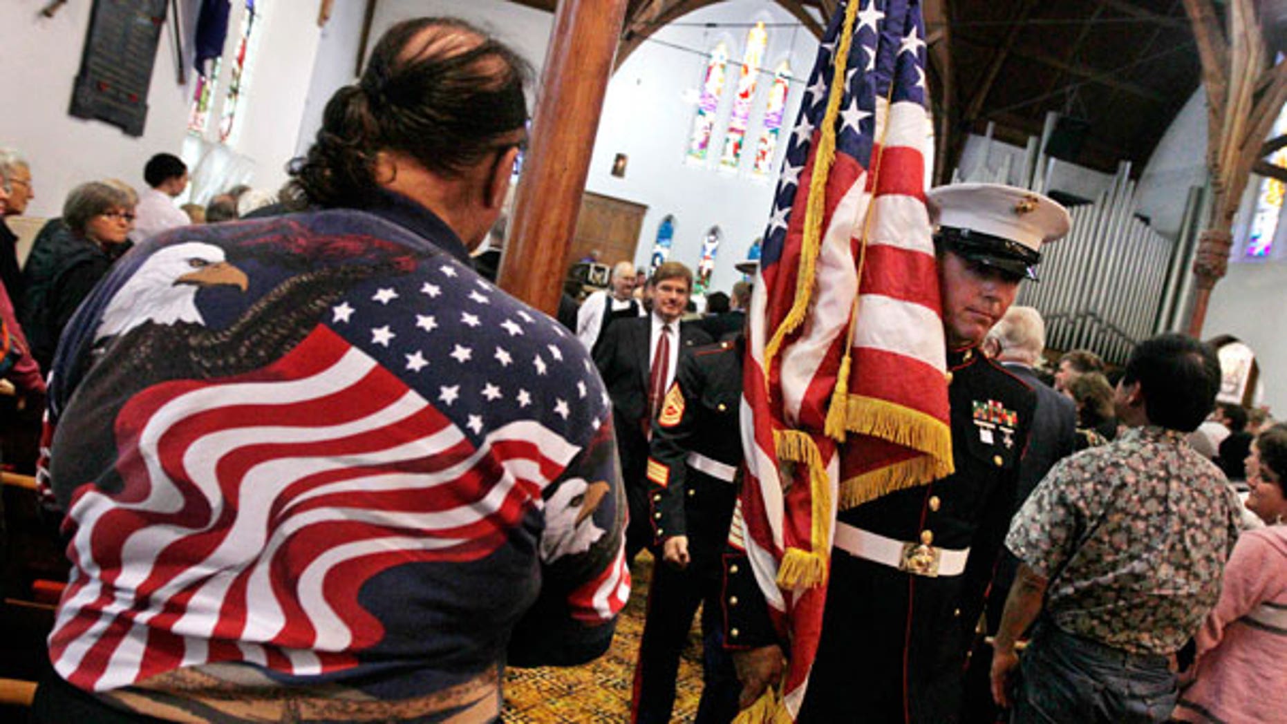 Sept. 11: A member of the U.S. Marines carries their national flag past a man wearing a stars and stripes shirt during a special service to commemorate the 10th anniversary of the Sept. 11 terrorist attacks, at a church in New Plymouth, New Zealand.