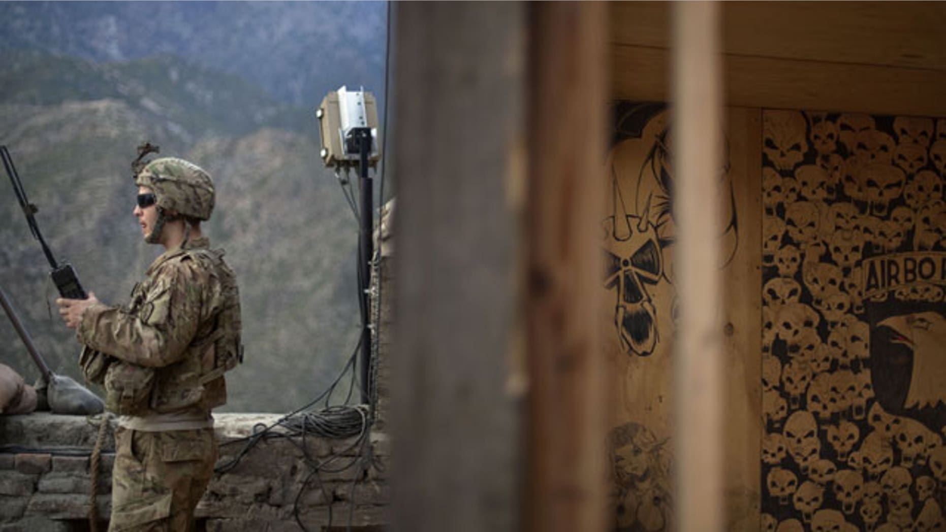 Sgt. Matt Murray, 25, of Warwick, RI., with the U.S. Army's Bravo Company of the 25th Infantry Division, 3rd Brigade Combat Team, 2nd Battalion 27th Infantry Regiment based in Schofield Barracks, Hawaii, listens to the radio next to graffiti left by a previous unit after receiving reports of an impending attack by insurgents Friday, Sept. 9, 2011 at Observation Post Coleman in Kunar province, Afghanistan.