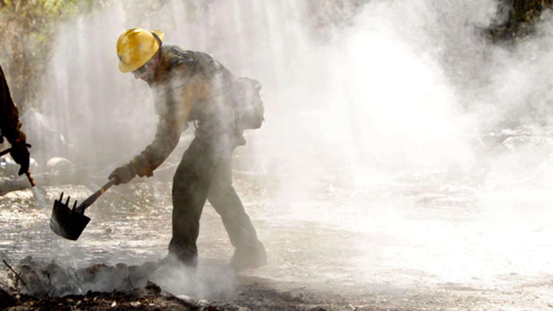 Sept. 10: Tommy Ratto, a fire fighter from the Lassen National Forest in Calif., team cleans up a hot spot after the destructive wildfire in Bastrop, Texas.