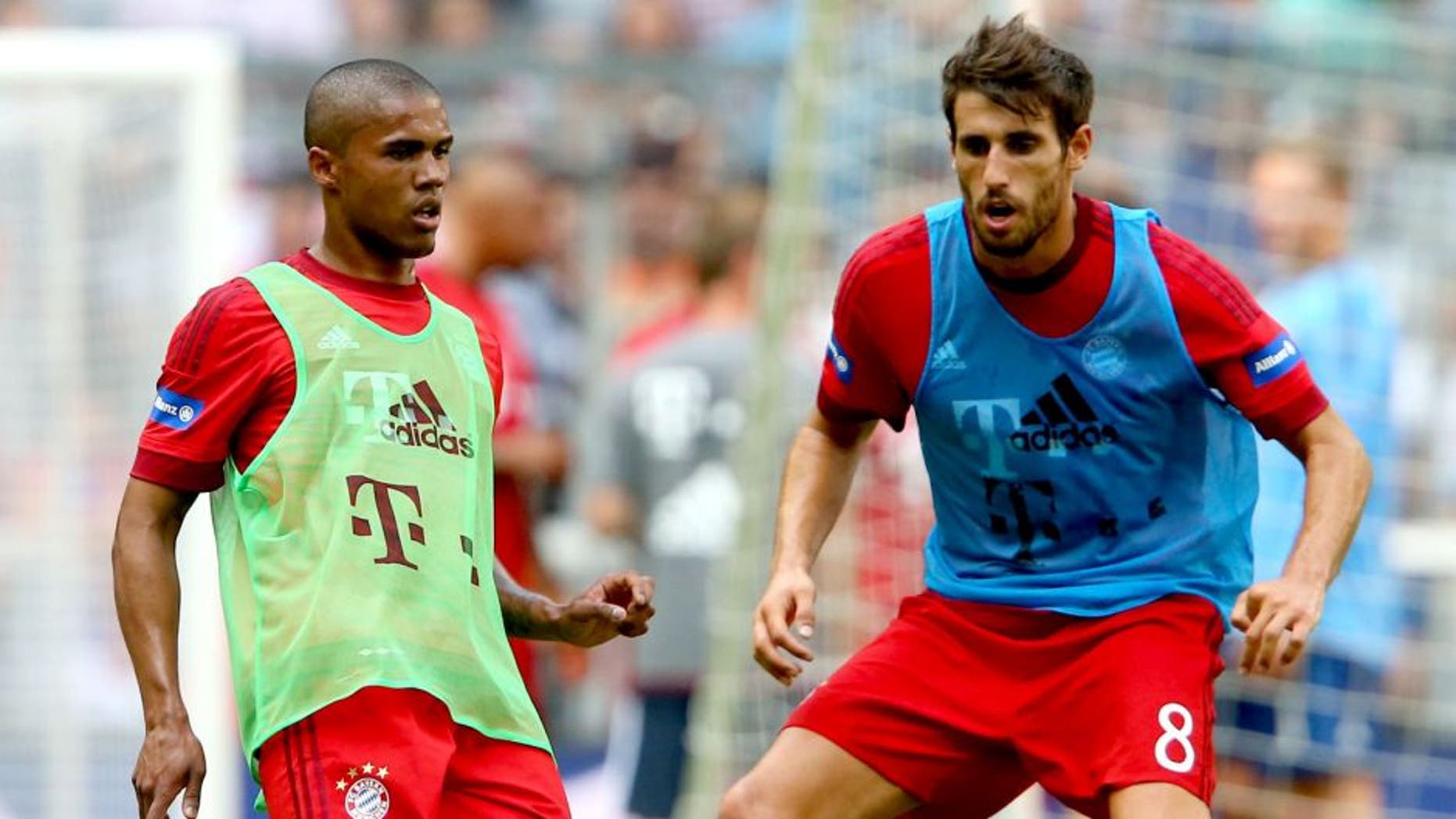MUNICH, GERMANY - JULY 11: Douglas Costa (L) battles for the ball with Javier Martinez during a training session after the FC Bayern Muenchen season opening and team presentation at Allianz Arena on July 11, 2015 in Munich, Germany. (Photo by Alexander Hassenstein/Bongarts/Getty Images)