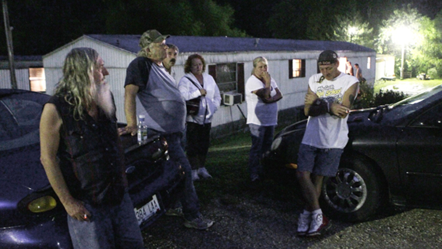 Sept. 11: Friends and neighbors gather with J.D. Kilborn, right, outside the trailer where Stanley Neace killed Kilborn's wife Tammy in Jackson, Ky. Neace killed five people before killing himself.
