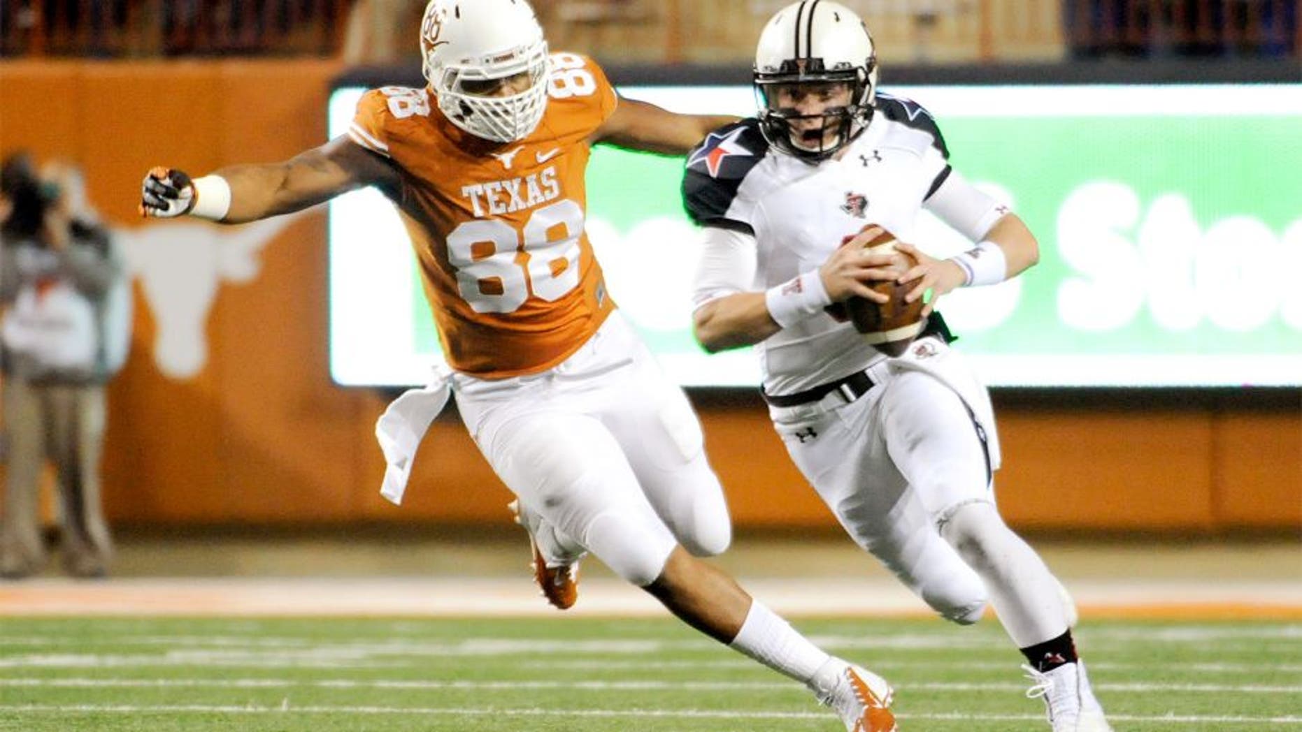 Nov 28, 2013; Austin, TX, USA; Texas Tech Red Raiders quarterback Baker Mayfield (6) away from Texas Longhorns defensive end Cedric Reed (88) during the first quarter at Darrell K Royal-Texas Memorial Stadium. Mandatory Credit: Brendan Maloney-USA TODAY Sports