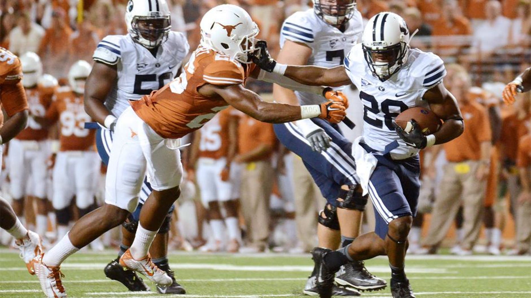Sep 6, 2014; Austin, TX, USA; Brigham Young Cougars running back Adam Hine (28) runs for a touchdown against Texas Longhorns safeties Adrian Colbert (l) and Mykkele Thompson (2) during the second half at Darrell K Royal-Texas Memorial Stadium. BYU beat Texas 41-7. Mandatory Credit: Brendan Maloney-USA TODAY Sports