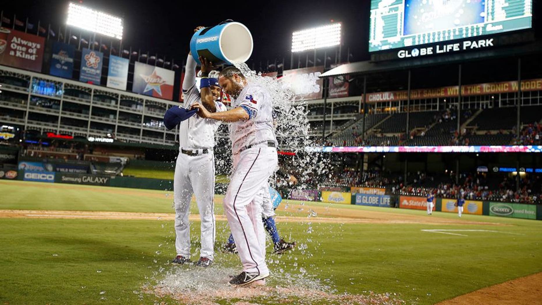 Sep 11, 2015; Arlington, TX, USA; Texas Rangers starting pitcher Colby Lewis (48) has water dumped on him by shortstop Elvis Andrus (1) after winning the game against the Oakland Athletics at Globe Life Park in Arlington. Texas won 4-0. Mandatory Credit: Tim Heitman-USA TODAY Sports