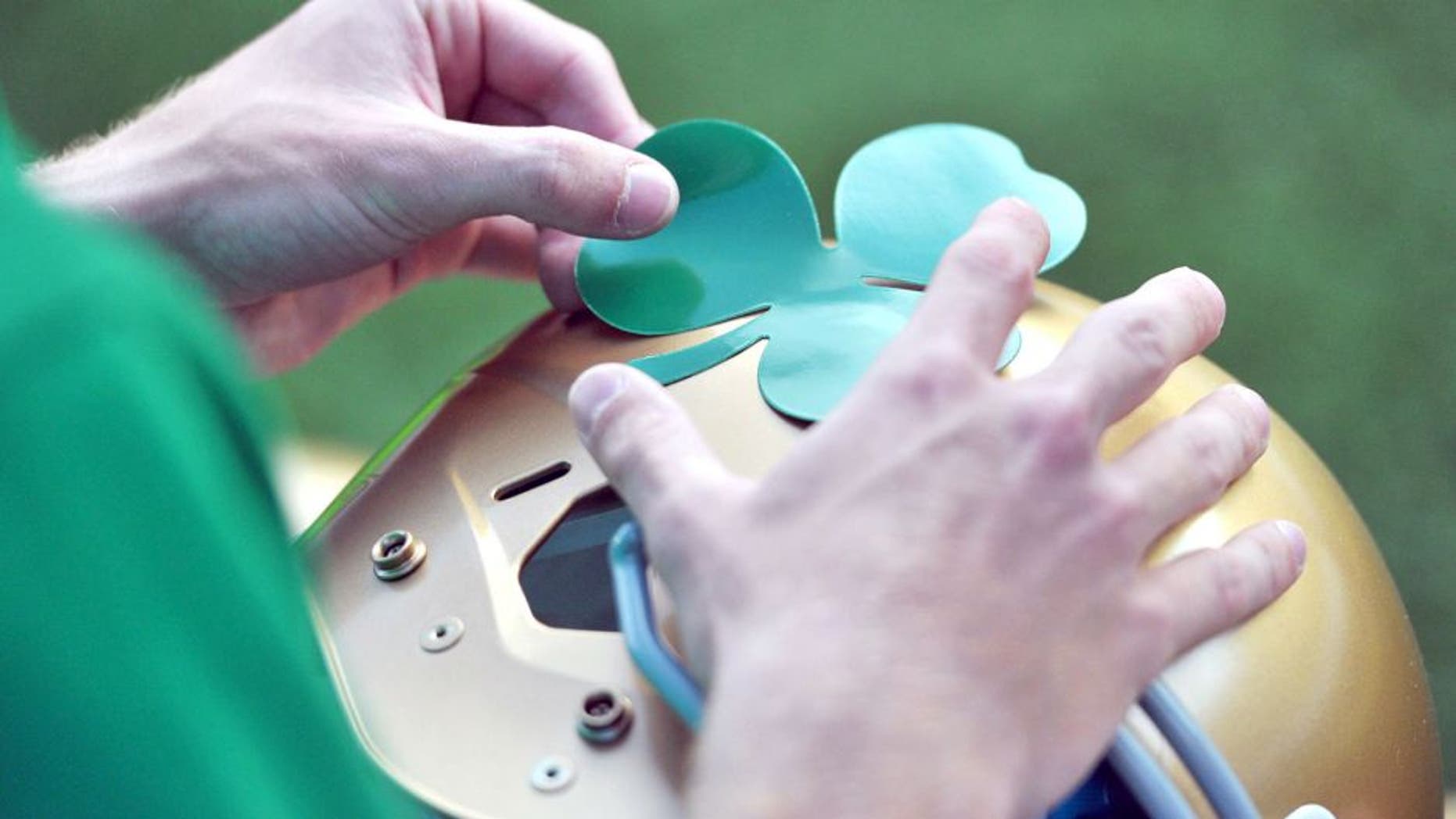 Sept. 10, 2011; Ann Arbor, MI, USA; A student manager applies a shamrock decal to a Notre Dame helmet before the game between the Notre Dame Fighting Irish and the Michigan Wolverines at Michigan Stadium. Mandatory Credit: Matt Cashore-USA TODAY Sports