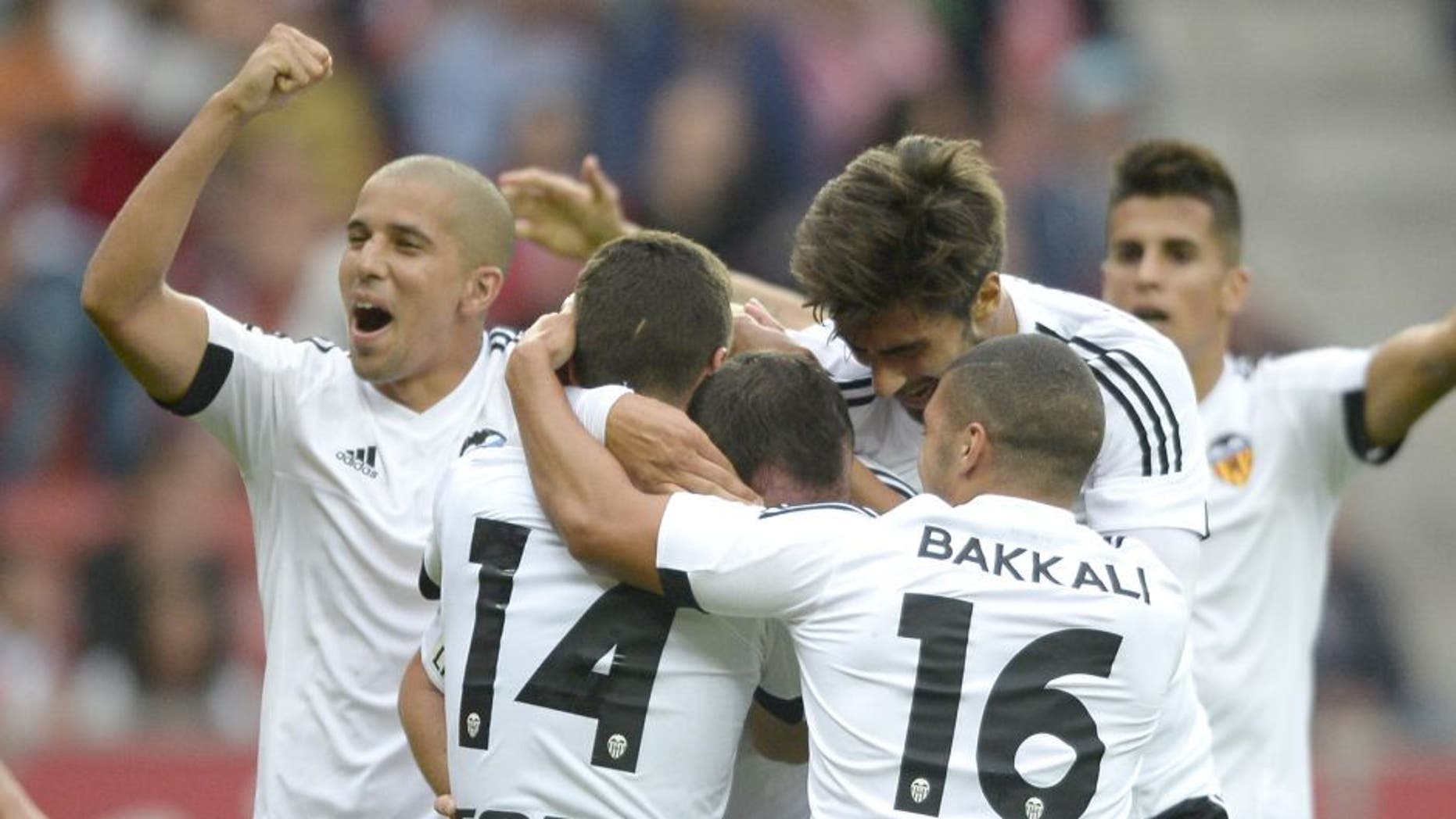 Valencia players celebrate after scoring a goal during the Spanish league football match Real Sporting de Gijon vs Valencia CF at El Molinon stadium in Gijon on September 12, 2015. Valencia won the match 1-0. AFP PHOTO/ MIGUEL RIOPA (Photo credit should read MIGUEL RIOPA/AFP/Getty Images)