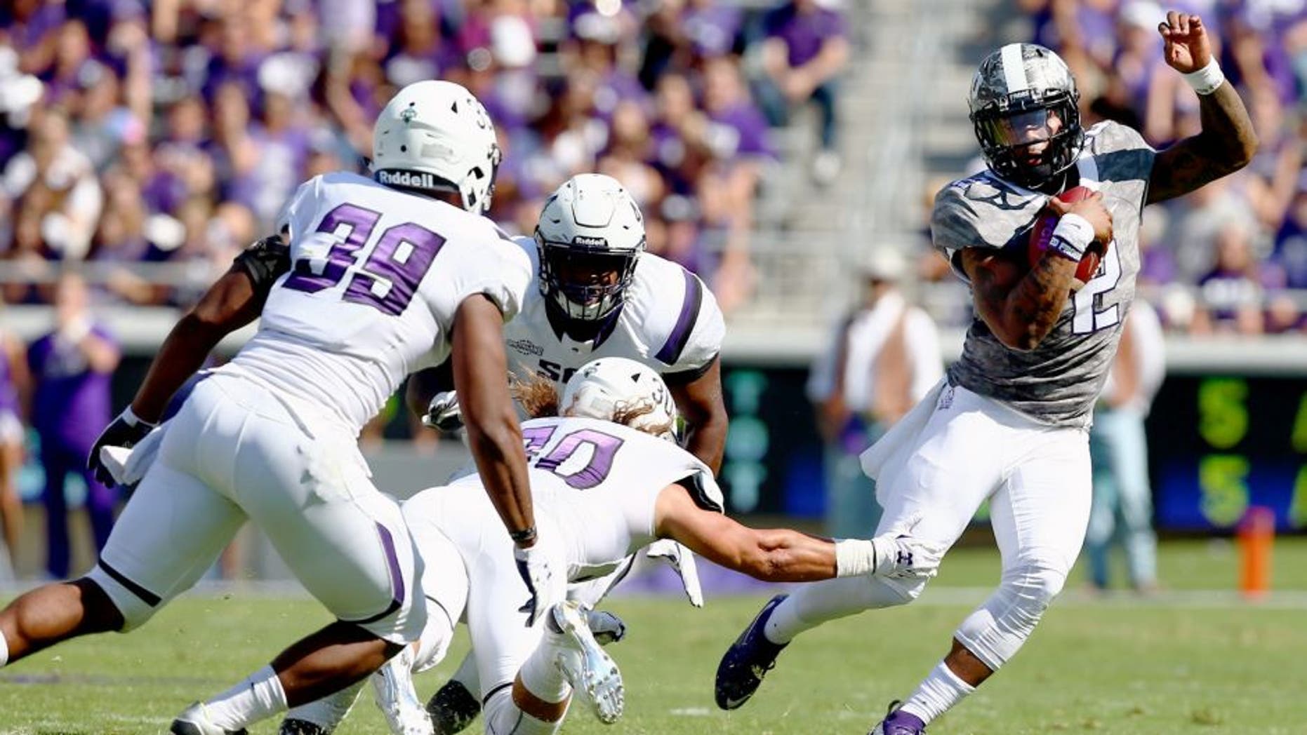 FORT WORTH, TX - SEPTEMBER 12: Trevone Boykin #2 of the TCU Horned Frogs carries the ball against Chance Barney #39 of the Stephen F. Austin Lumberjacks and Justin Owens #30 of the Stephen F. Austin Lumberjacks in the second quarter at Amon G. Carter Stadium on September 12, 2015 in Fort Worth, Texas. (Photo by Tom Pennington/Getty Images)