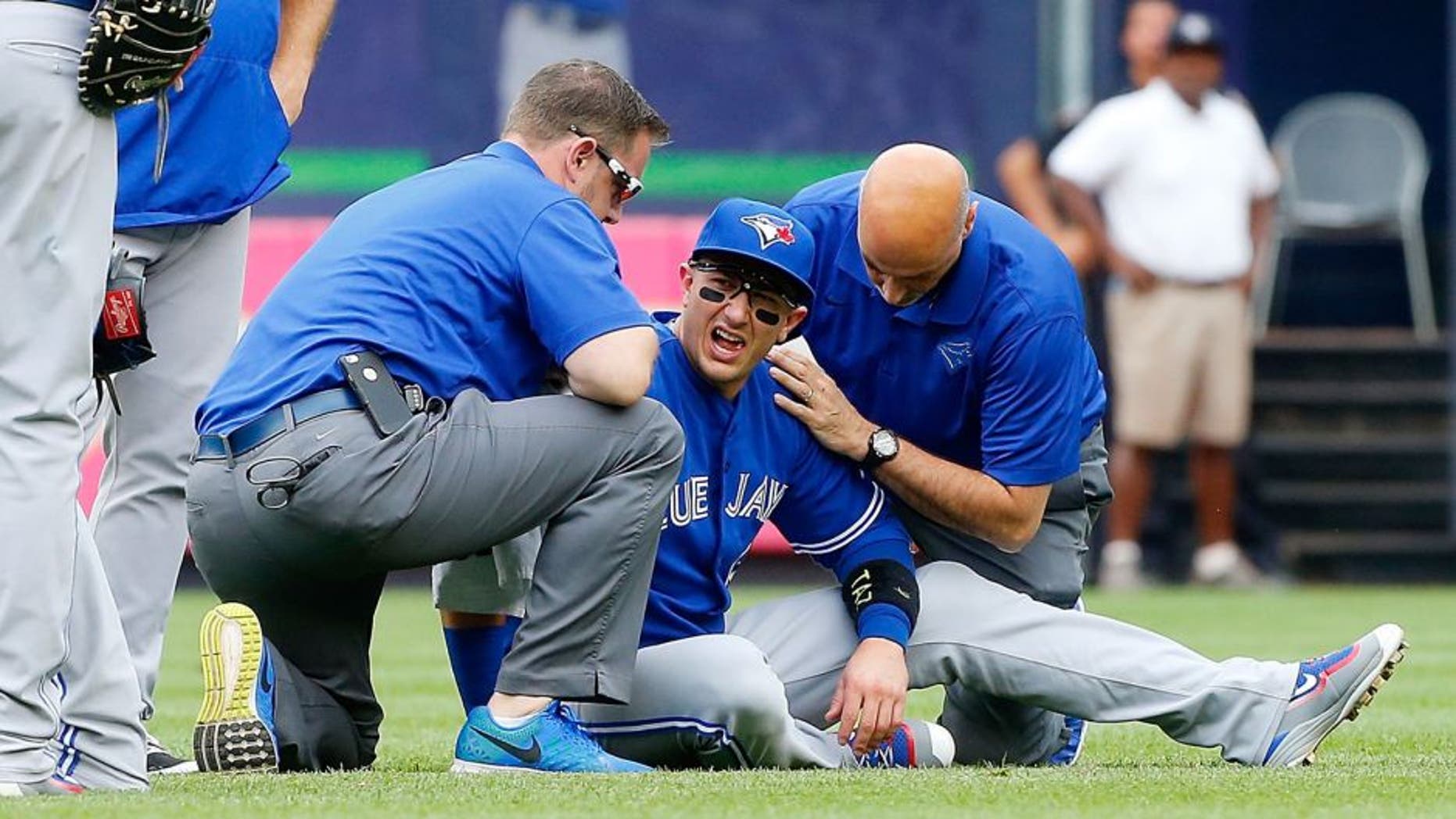 NEW YORK, NY - SEPTEMBER 12: Troy Tulowitzki #2 of the Toronto Blue Jays is tended to by team personnel after colliding with a teammate while making a catch for the final out of the second inning against the New York Yankees at Yankee Stadium on September 12, 2015 in the Bronx borough of New York City. (Photo by Jim McIsaac/Getty Images)