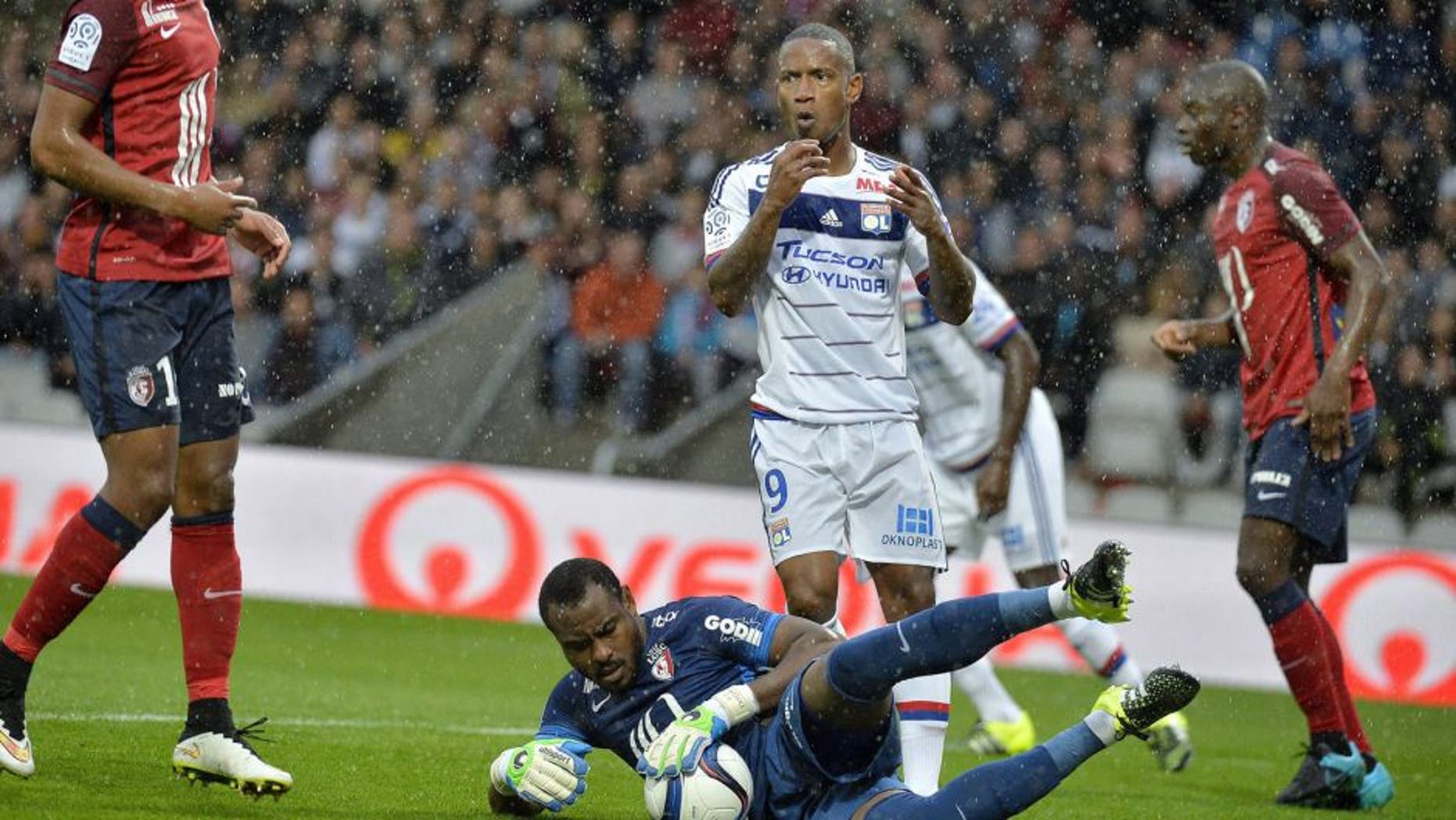 Lille's Nigerian goalkeeper Vincent Enyeama (C, bottom) blocks a shot on goal by Lyon's French forward Claudio Beauvue (back) during the French L1 football match between Lyon and Lille at the Gerland stadium in Lyon, eastern France, on September 12, 2015. AFP PHOTO / ROMAIN LAFABREGUE (Photo credit should read ROMAIN LAFABREGUE/AFP/Getty Images)