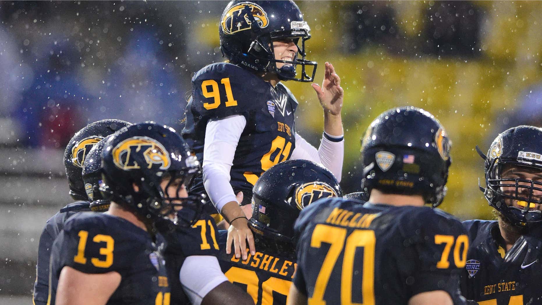 Sept. 12, 2015: Teammates carry Kent State's April Goss (91) off the field after she kicked an extra point during the second quarter against Delaware State in an NCAA college football game.