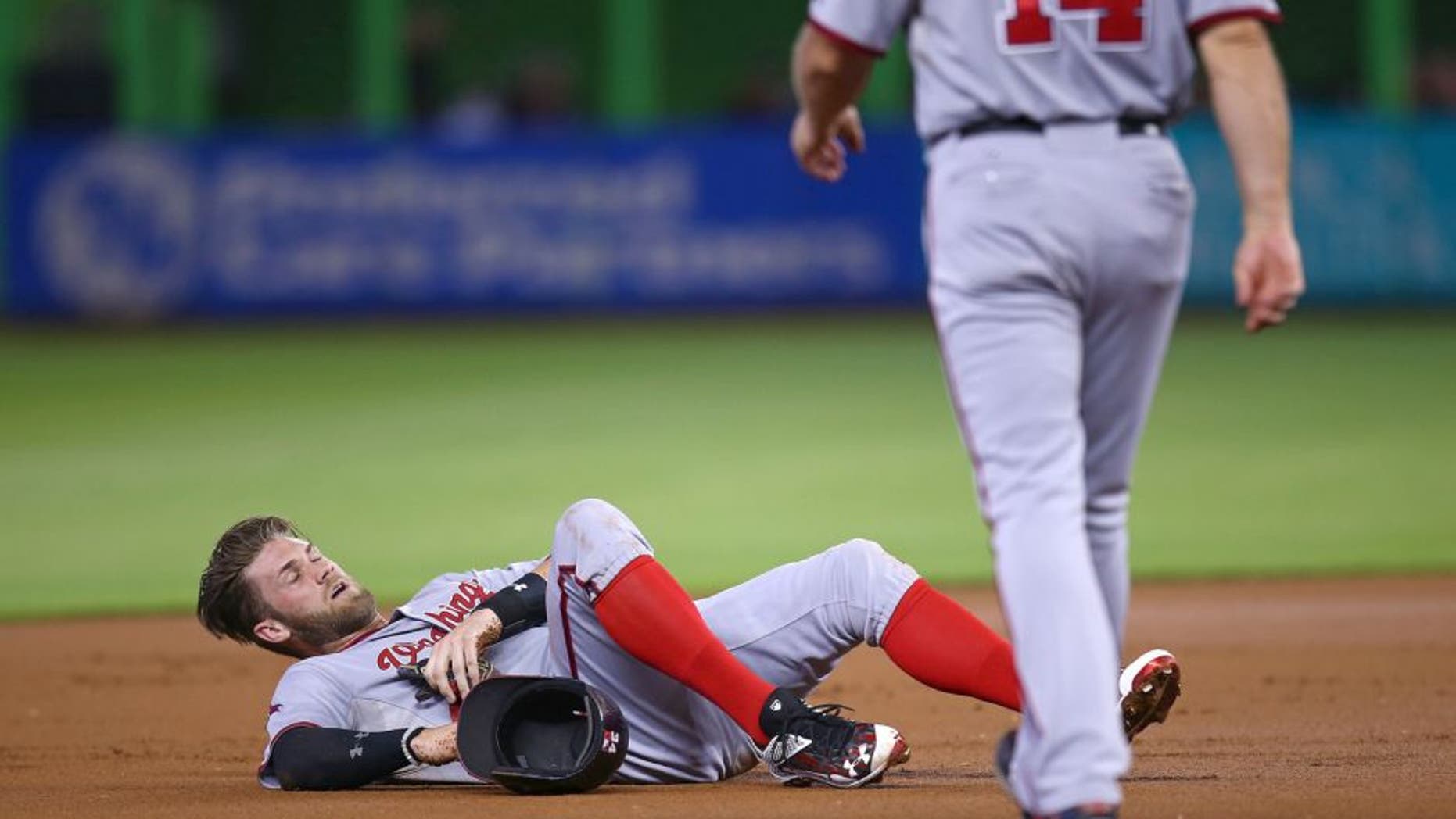 MIAMI, FL - SEPTEMBER 13: Bryce Harper #34 of the Washington Nationals lays injured on the infield after colliding with Miguel Rojas of the Miami Marlins during the first inning of the game at Marlins Park on September 13, 2015 in Miami, Florida. Harper was taken out of the game after the injury. (Photo by Rob Foldy/Getty Images)