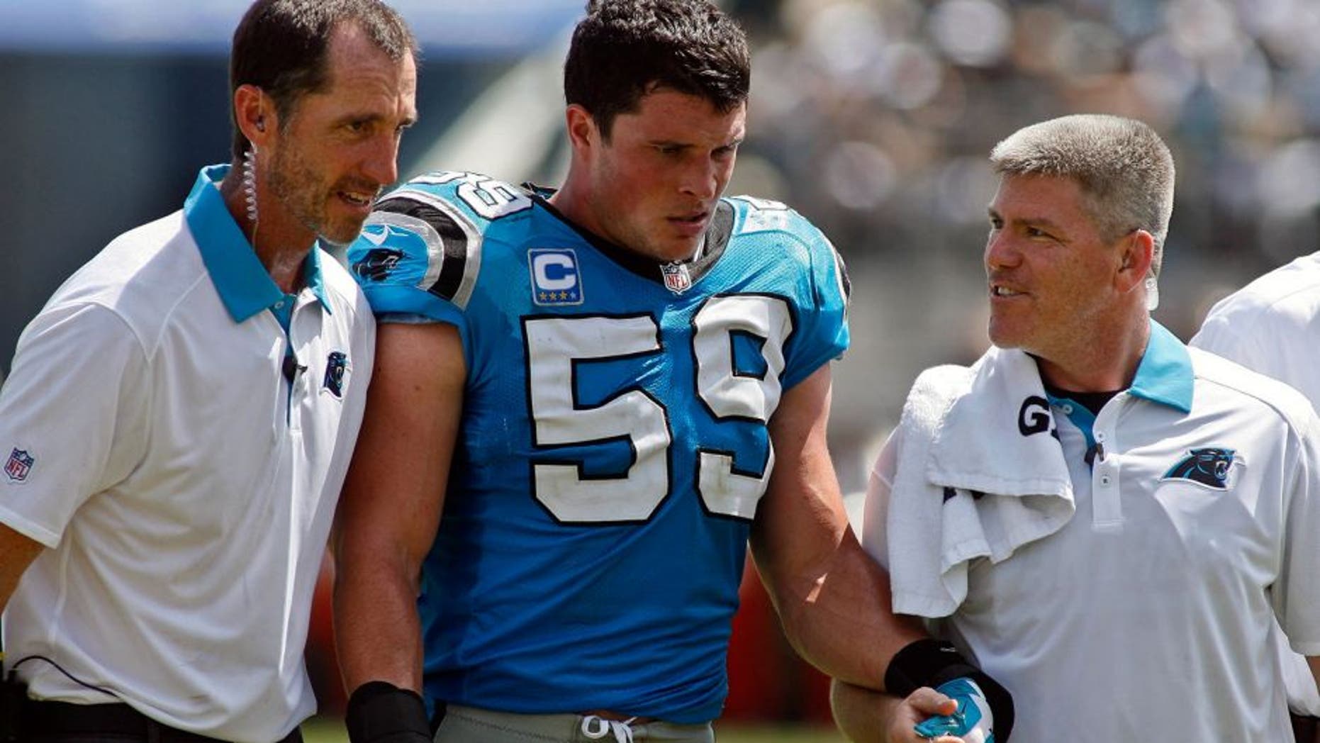 Sep 13, 2015; Jacksonville, FL, USA; Carolina Panthers middle linebacker Luke Kuechly (59) is escorted off the field in the second quarter of their game against the Jacksonville Jaguars at EverBank Field. The Carolina Panthers won 20-9. Mandatory Credit: Phil Sears-USA TODAY Sports
