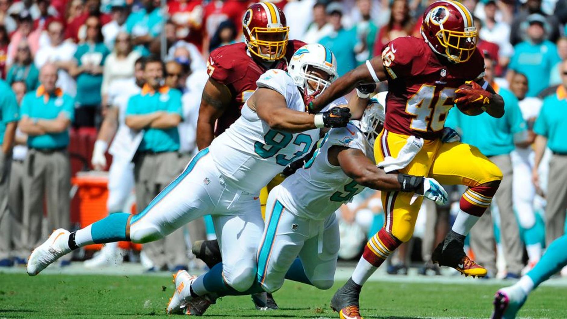 Sep 13, 2015; Landover, MD, USA; Washington Redskins running back Alfred Morris (46) is tackled by Miami Dolphins defensive tackle Ndamukong Suh (93) and outside linebacker Koa Misi (55) during the first half at FedEx Field. Mandatory Credit: Brad Mills-USA TODAY Sports