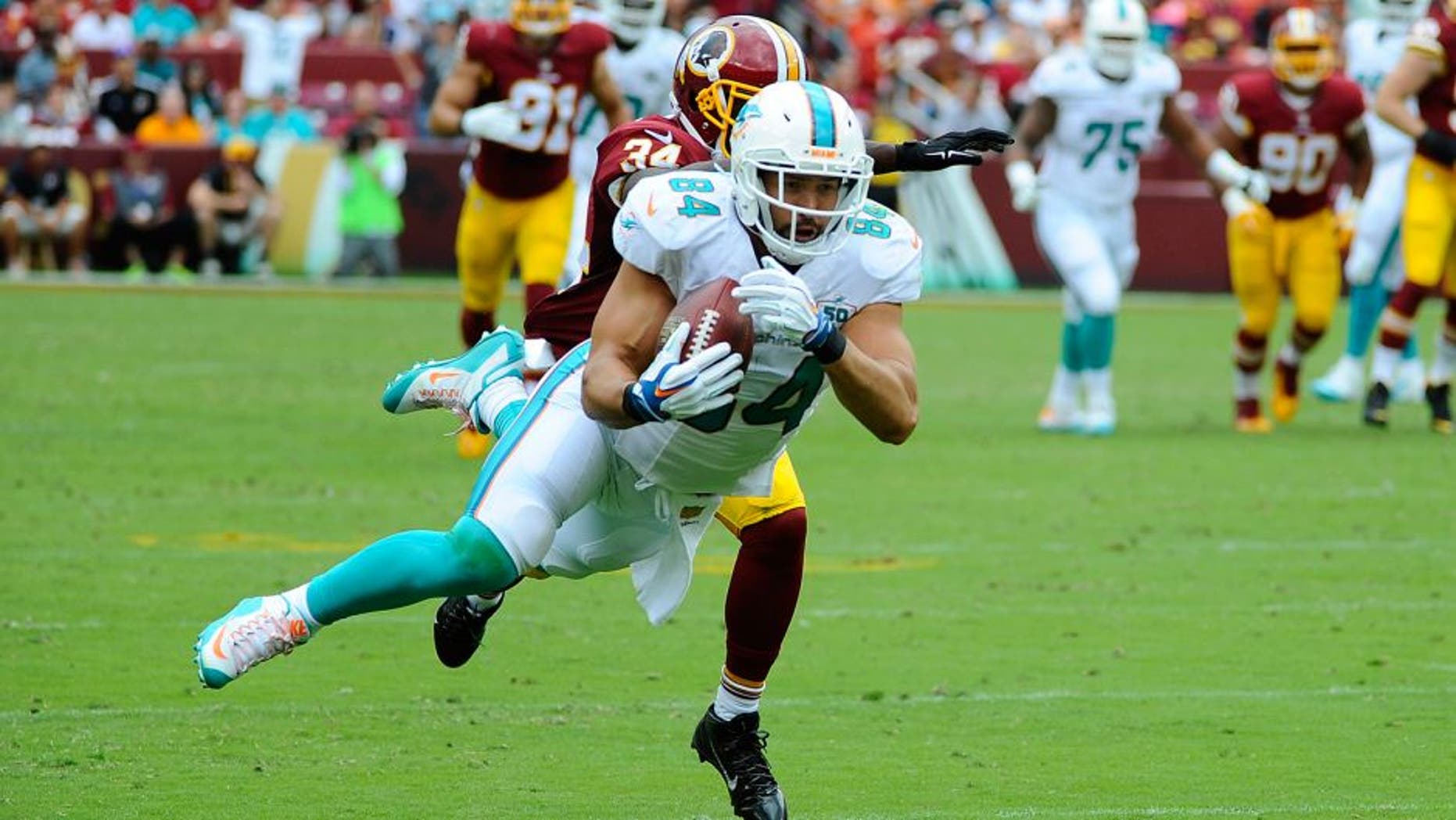Sep 13, 2015; Landover, MD, USA; Miami Dolphins tight end Jordan Cameron (84) makes a diving catch past Washington Redskins free safety Trenton Robinson (34) during the second half at FedEx Field. Mandatory Credit: Brad Mills-USA TODAY Sports