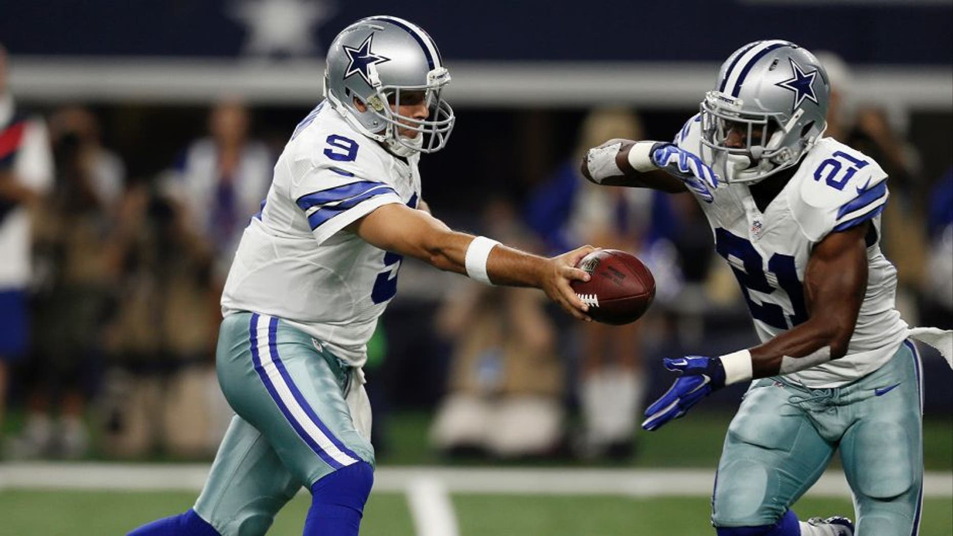 Dallas Cowboys quarterback Tony Romo (9) hands off the ball to running back Joseph Randle (21) during the first half of an NFL football game against the New York Giants, Sunday, Sept. 13, 2015, in Arlington, Texas. (AP Photo/Brandon Wade)