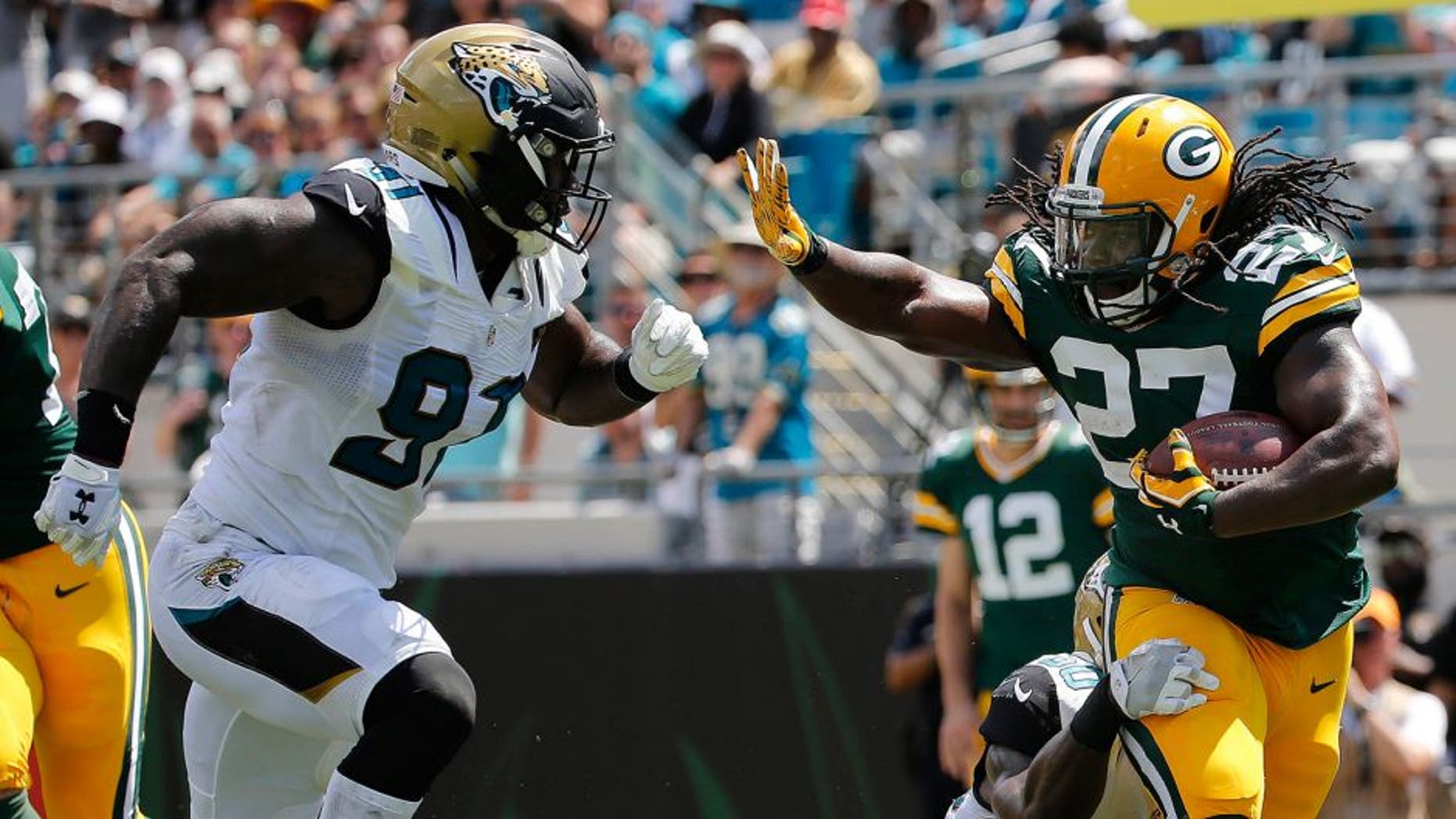 Sep 11, 2016; Jacksonville, FL, USA; Green Bay Packers running back Eddie Lacy (27) runs with he ball as Jacksonville Jaguars outside linebacker Telvin Smith (50) and defensive end Yannick Ngakoue (91) defends during the first half at EverBank Field. Mandatory Credit: Kim Klement-USA TODAY Sports