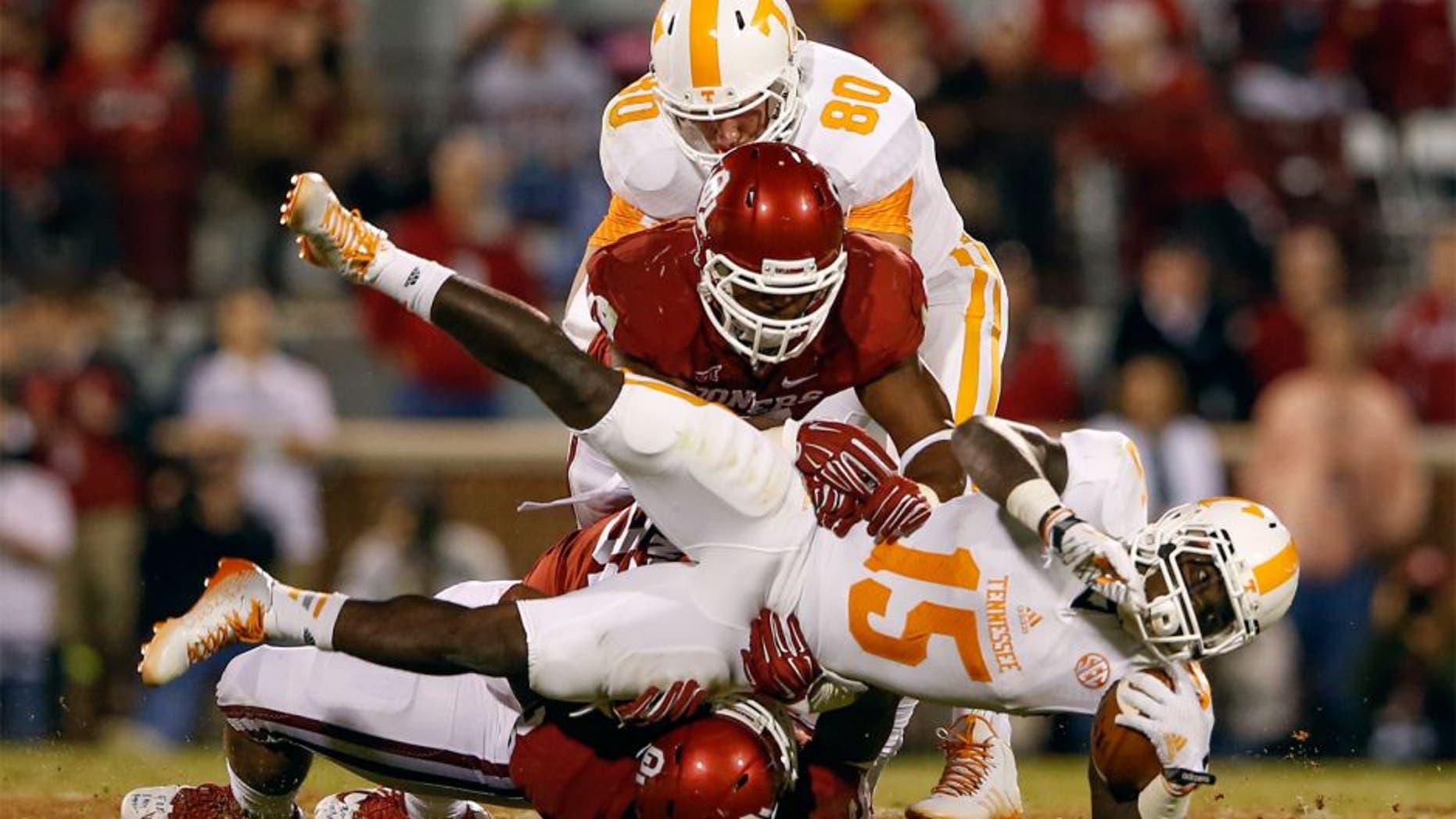 Sep 13, 2014; Norman, OK, USA; Tennessee Volunteers running back Marlin Lane (15) is tackled by Oklahoma Sooners linebacker Eric Striker (19) during the game at Gaylord Family - Oklahoma Memorial Stadium. Mandatory Credit: Kevin Jairaj-USA TODAY Sports