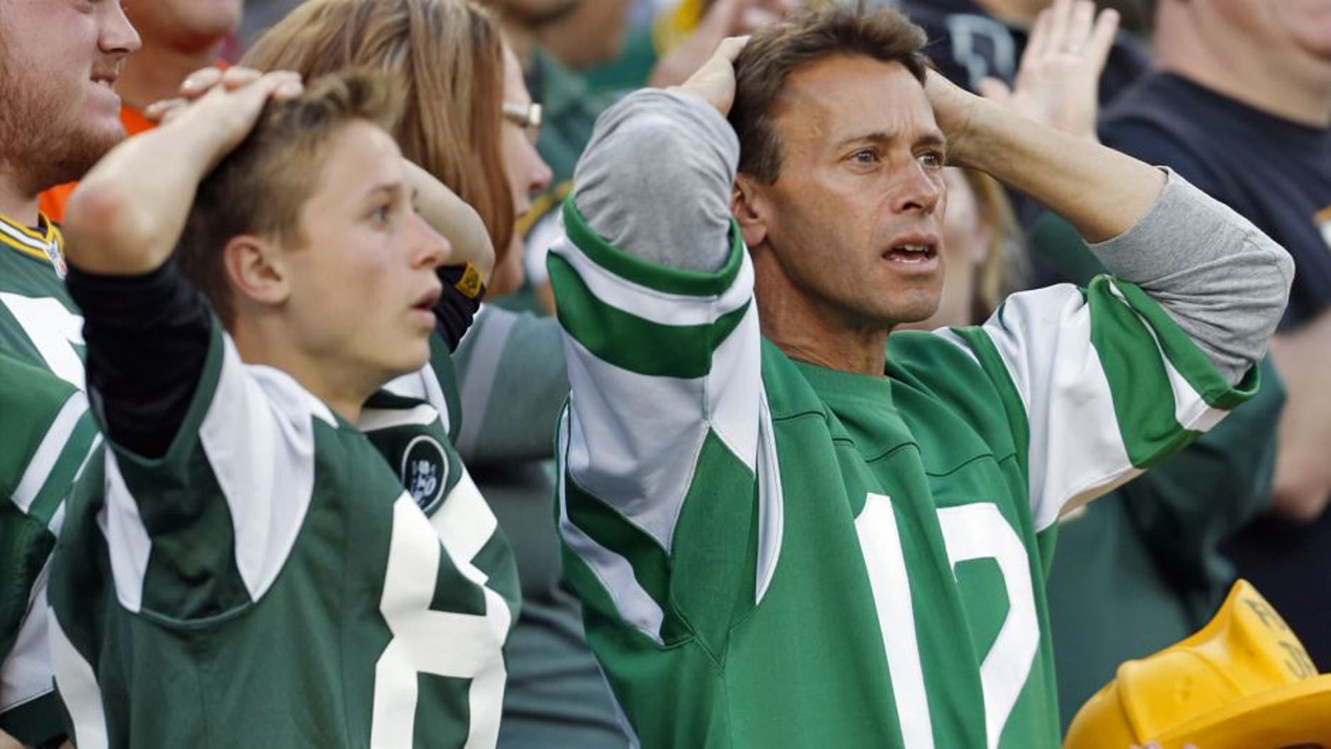 New York Jets fans react after a touchdown catch was called back because the team called a time out before the ball was snapped during the second half of an NFL football game against the Green Bay Packers Sunday, Sept. 14, 2014, in Green Bay, Wis. (AP Photo/Mike Roemer)