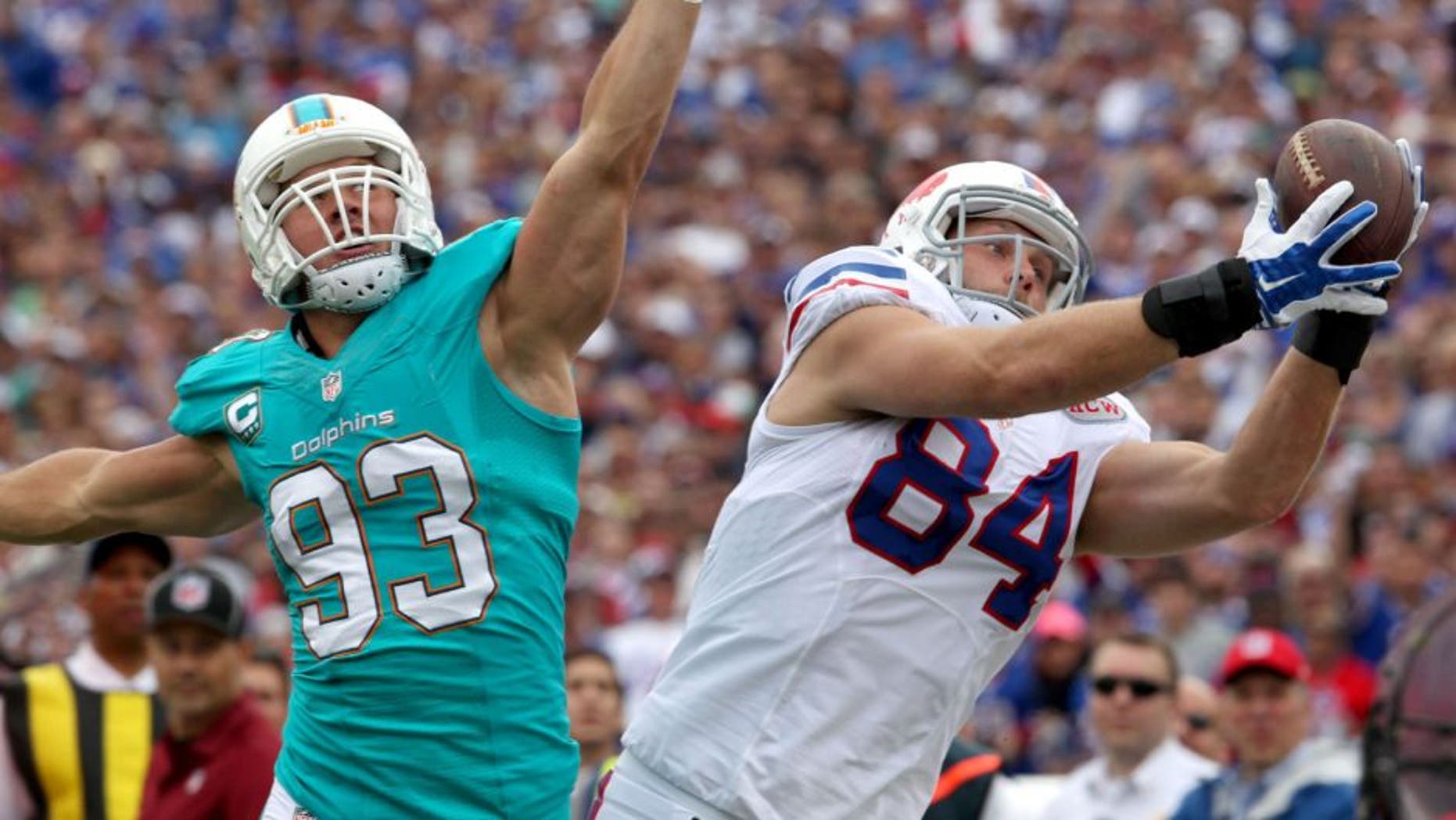 Sep 14, 2014; Orchard Park, NY, USA; Buffalo Bills tight end Scott Chandler (84) dives to make a catch while being defended by Miami Dolphins outside linebacker Jason Trusnik (93) during the first half at Ralph Wilson Stadium. Mandatory Credit: Timothy T. Ludwig-USA TODAY Sports