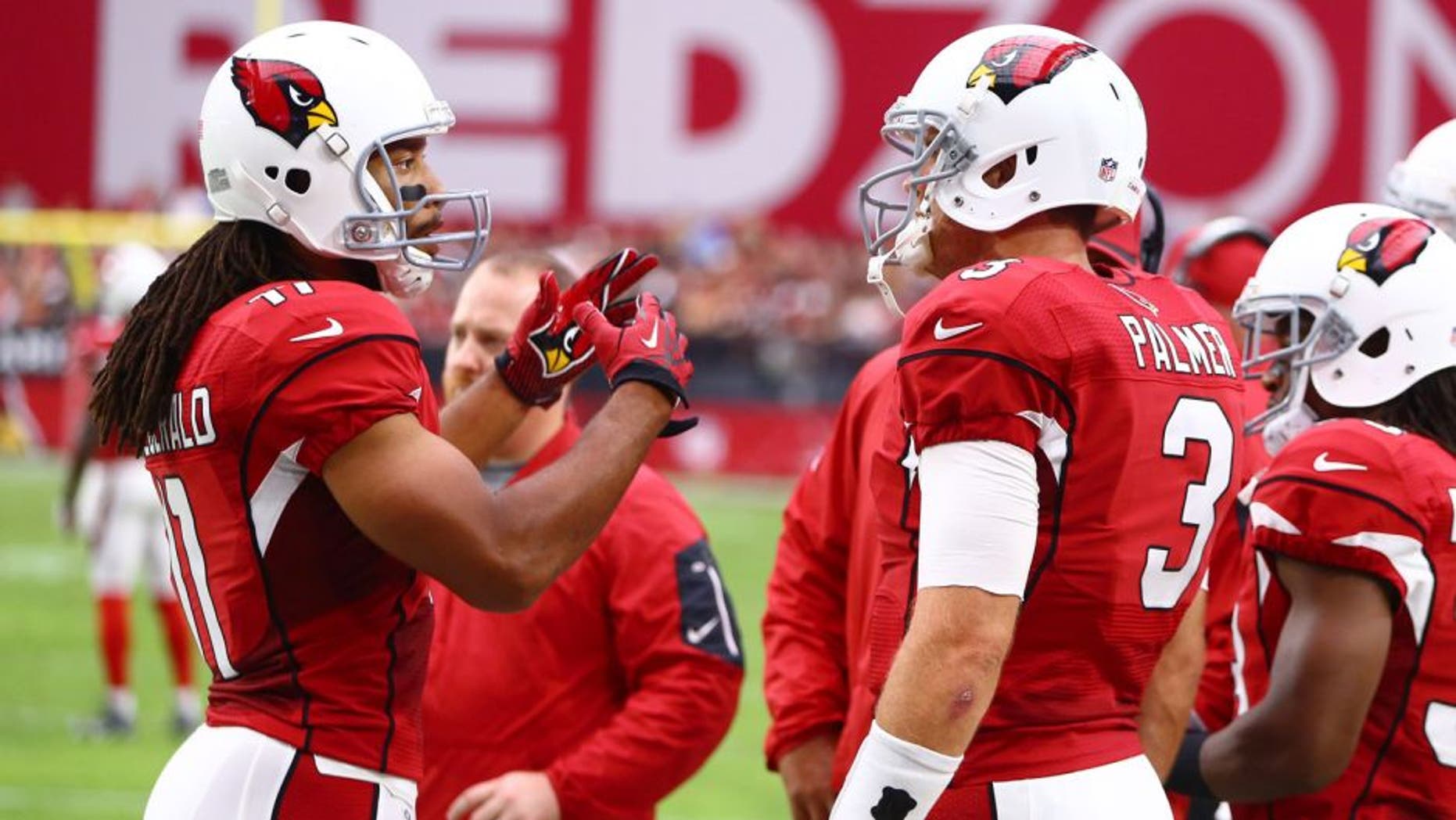 Sep 13, 2015; Glendale, AZ, USA; Arizona Cardinals wide receiver Larry Fitzgerald (left) talks with quarterback Carson Palmer on the sidelines in the first half against the New Orleans Saints at University of Phoenix Stadium. The Cardinals defeated the Saints 31-19. Mandatory Credit: Mark J. Rebilas-USA TODAY Sports