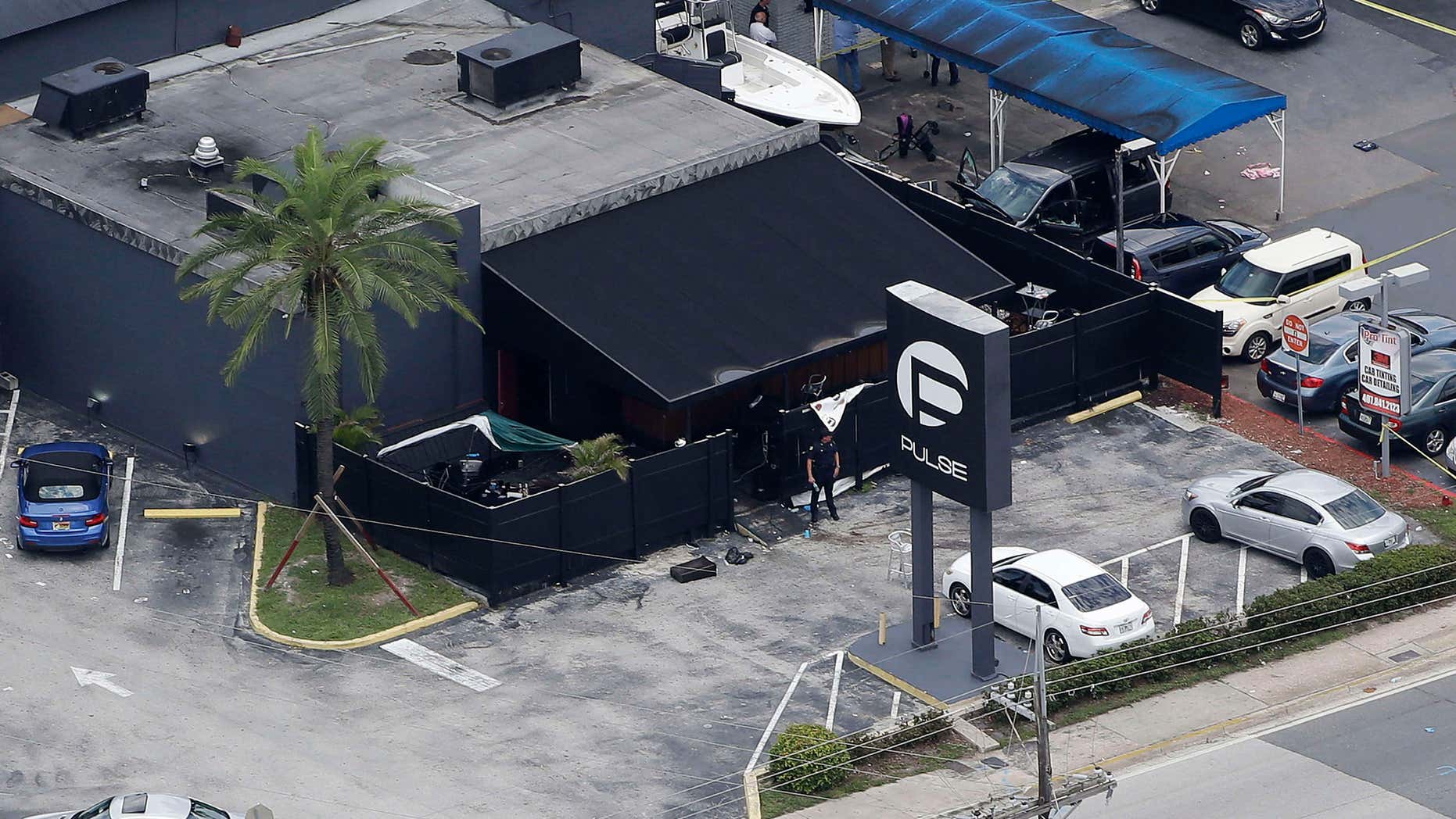 FILE - In this June 12, 2016 file photo, law enforcement officials work at the Pulse gay nightclub in Orlando, Fla., following a mass shooting.
