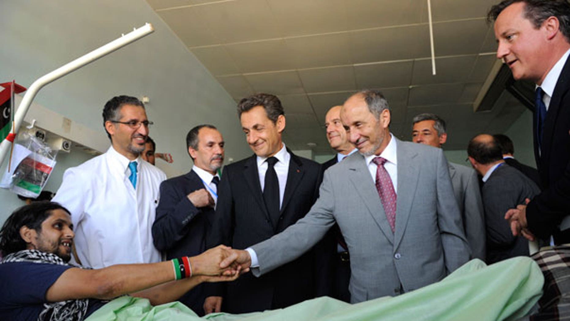 Sept. 15: Leader of Libya's interim government, Mustafa Abdul-Jalil shakes hands with with an unidentified injured man while French President Nicolas Sarkozy, center, and Britain's Prime Minister David Cameron, right, look on in the Tripoli Medical center.