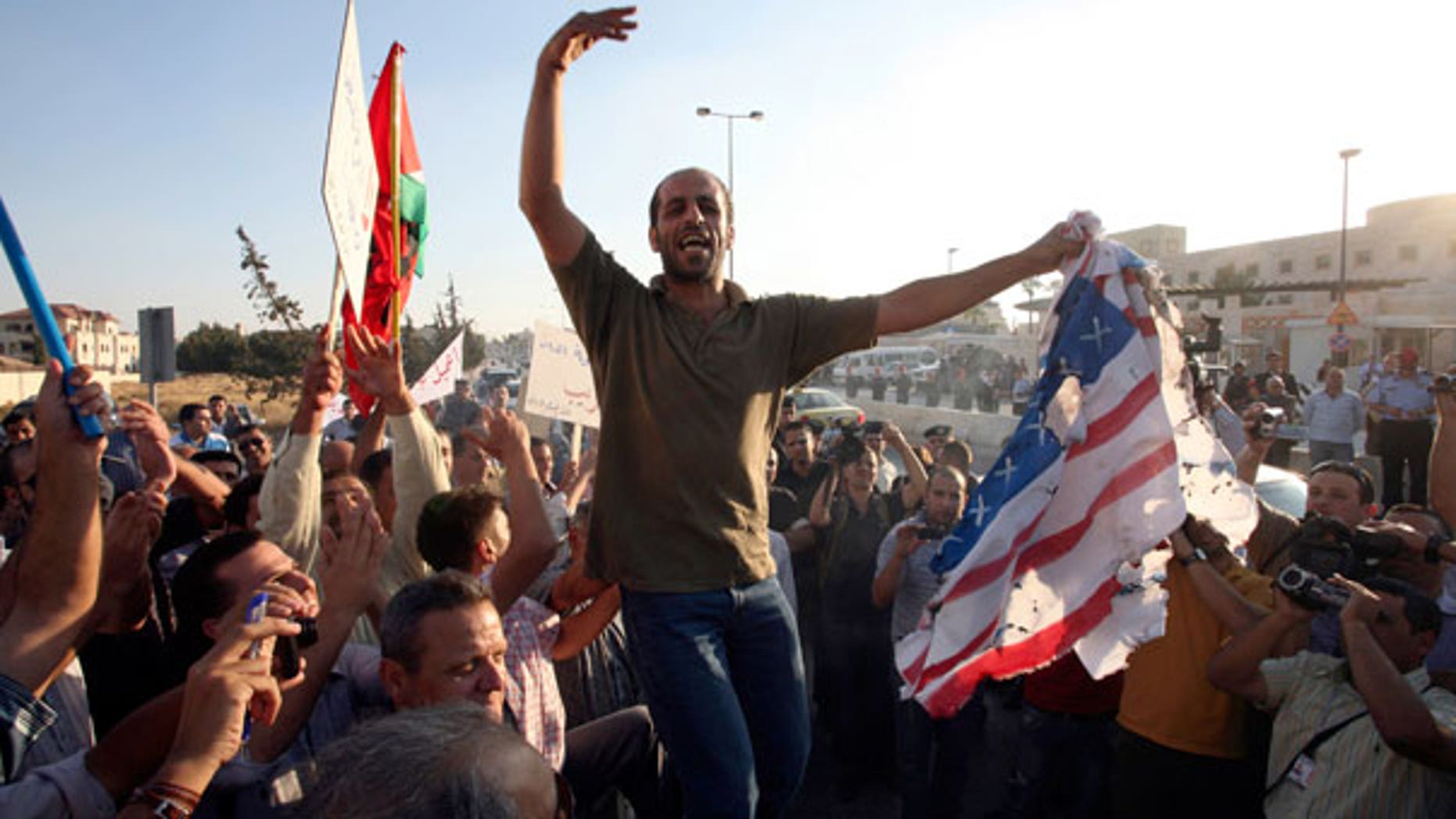 Sept. 14: Jordanian protesters chant anti U.S.A. slogans and burn the American and the Israeli flags in front of the U.S. embassy in Amman, Jordan.